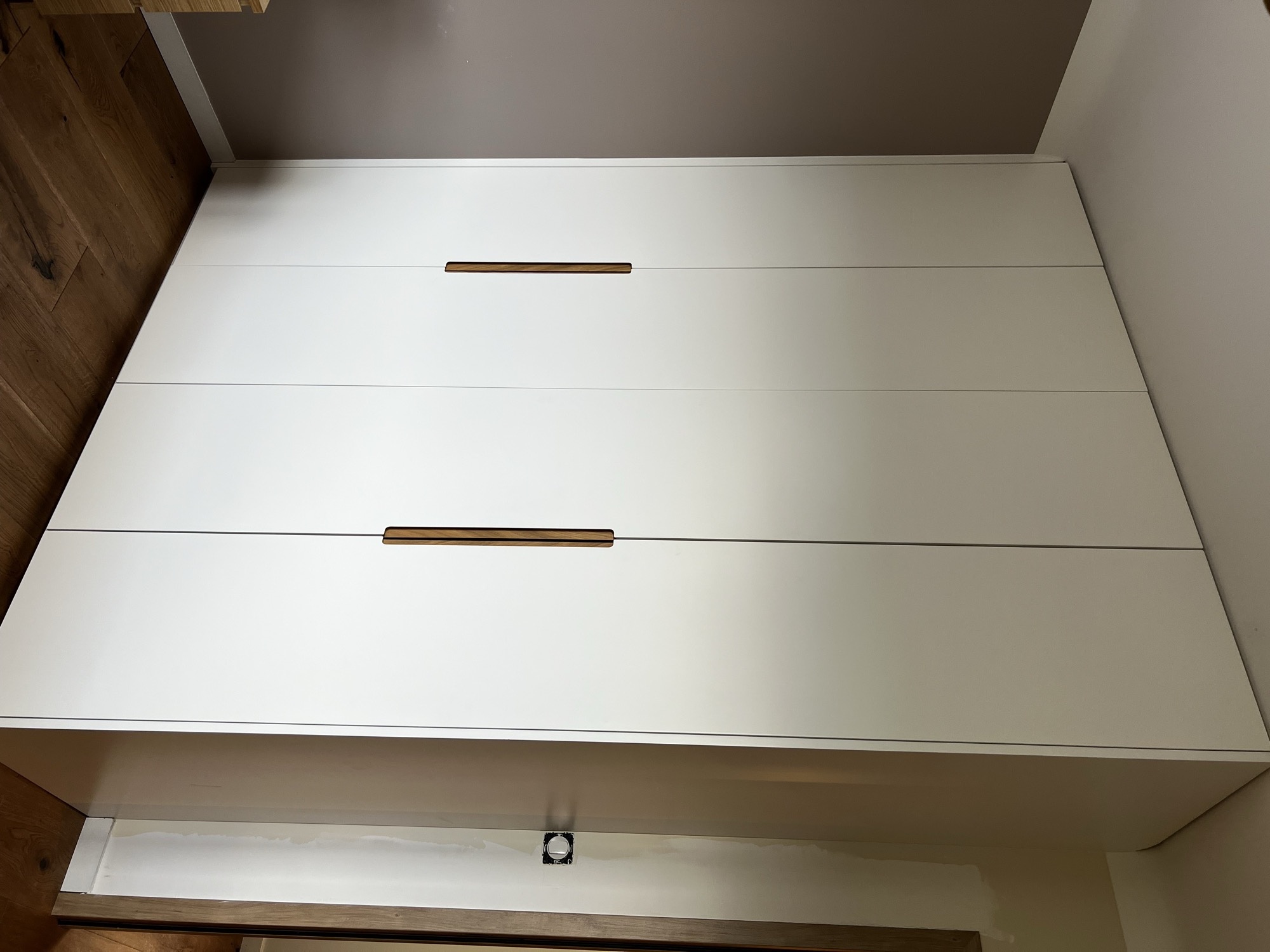 Roupeiro branco de quatro portas com puxadores em madeira