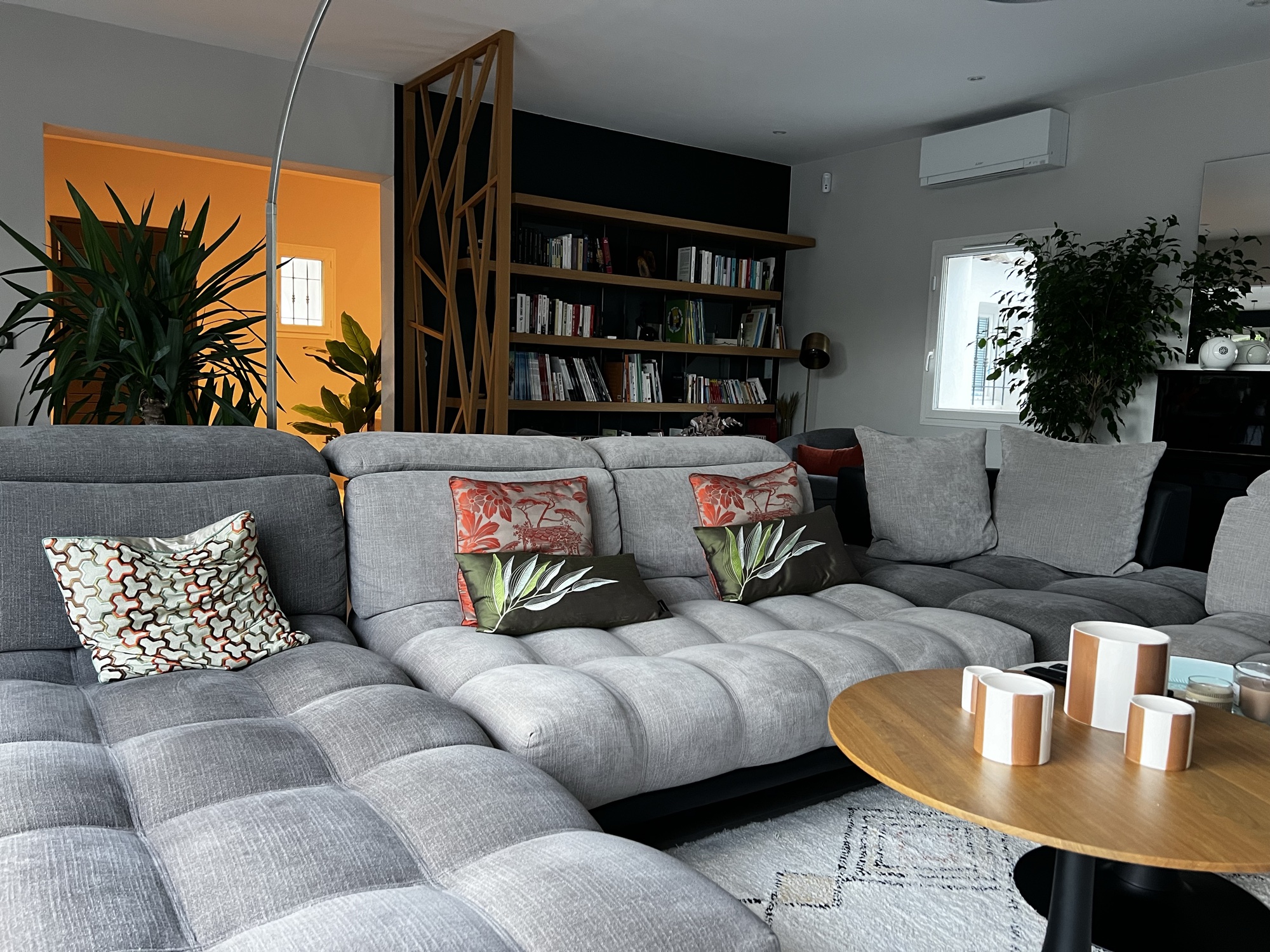 Sala com sofá cinzento e estante de livros