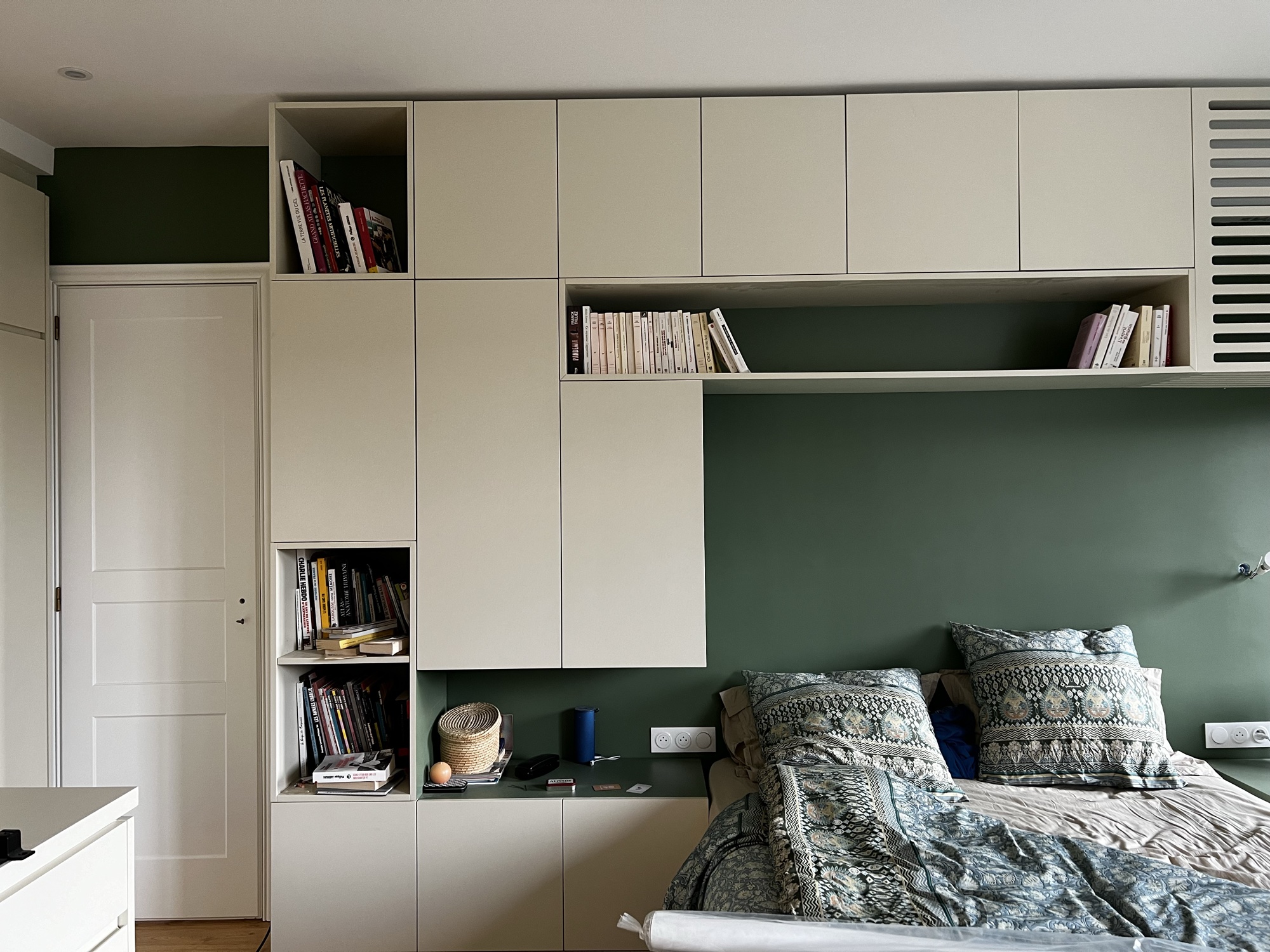 Quarto verde com estante integrada na cabeceira