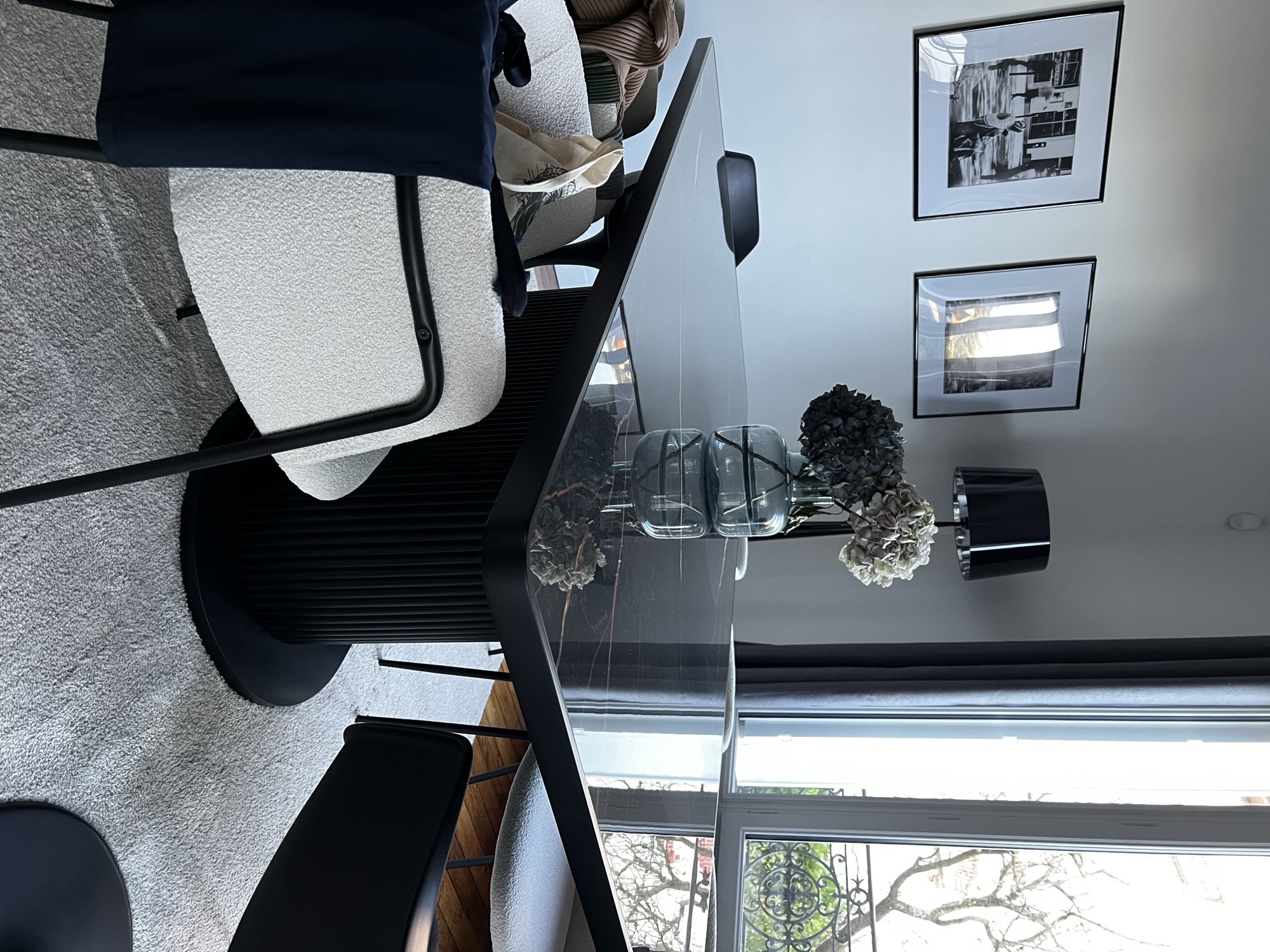 Mesa preta com vasos e cadeira boucle