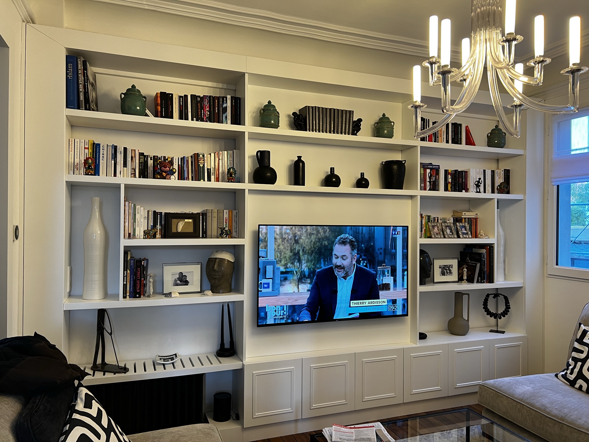 Estante branca com TV e candelabro