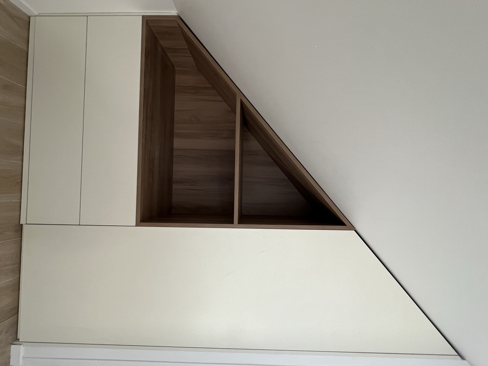 Armário creme sob escada com nichos