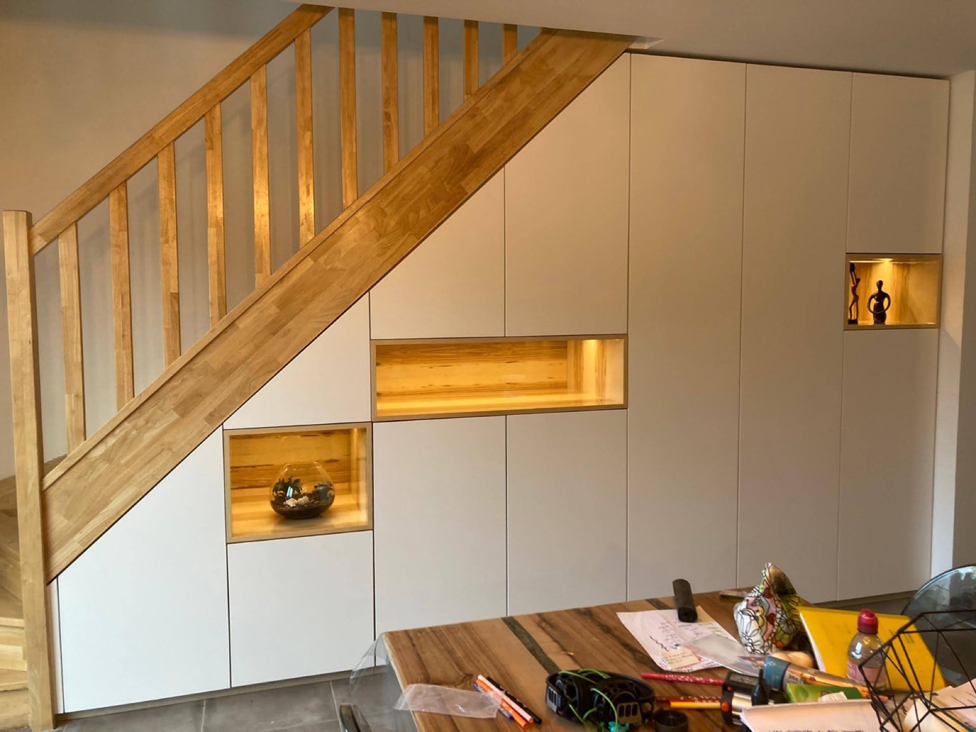 Armários brancos sob escada em madeira