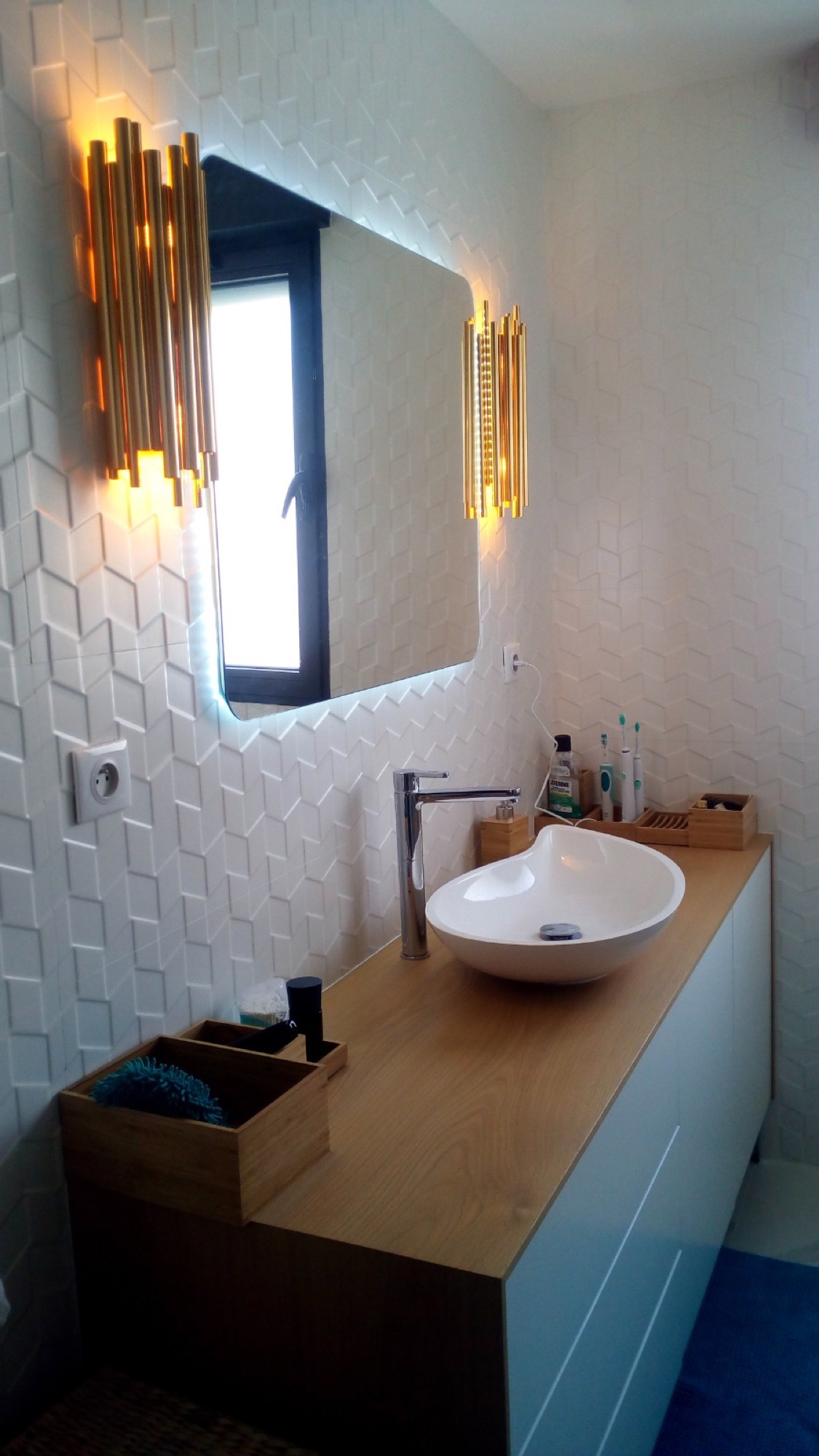 Casa de banho com móvel de madeira e apliques dourados