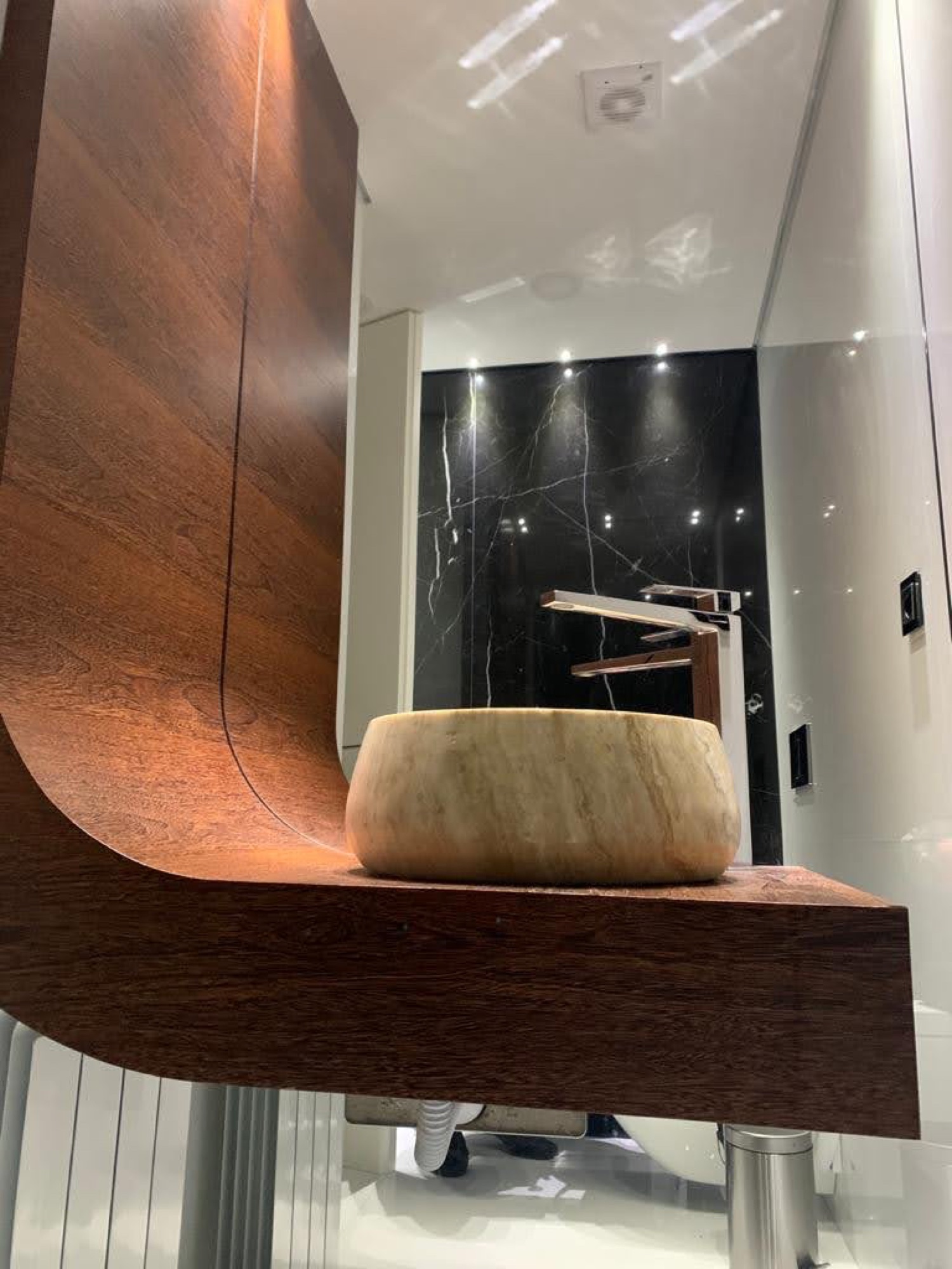 Lavatório em pedra sobre bancada de madeira