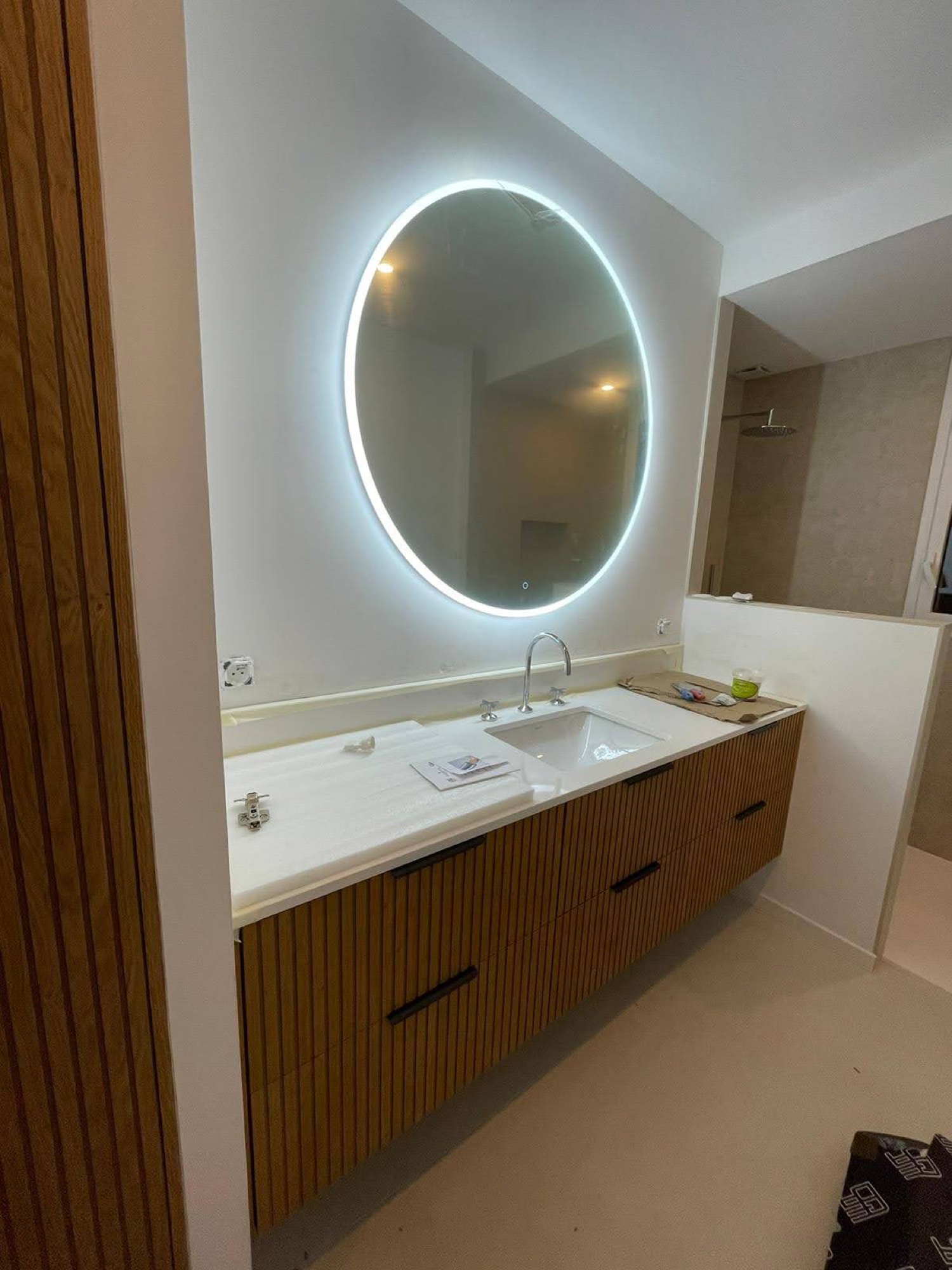 Móvel em madeira ripada com espelho redondo