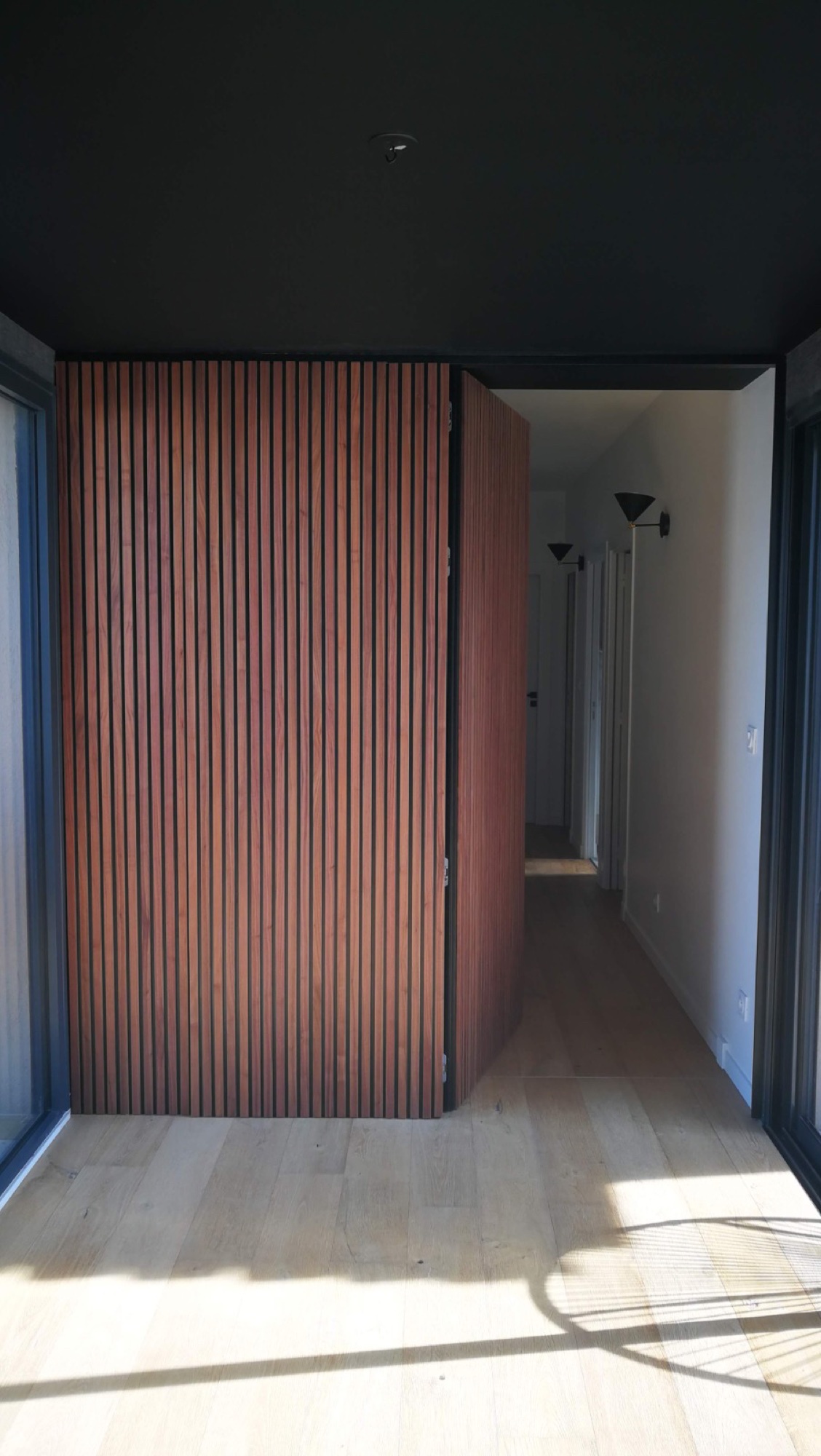 Corredor com revestimento em ripado vertical de madeira