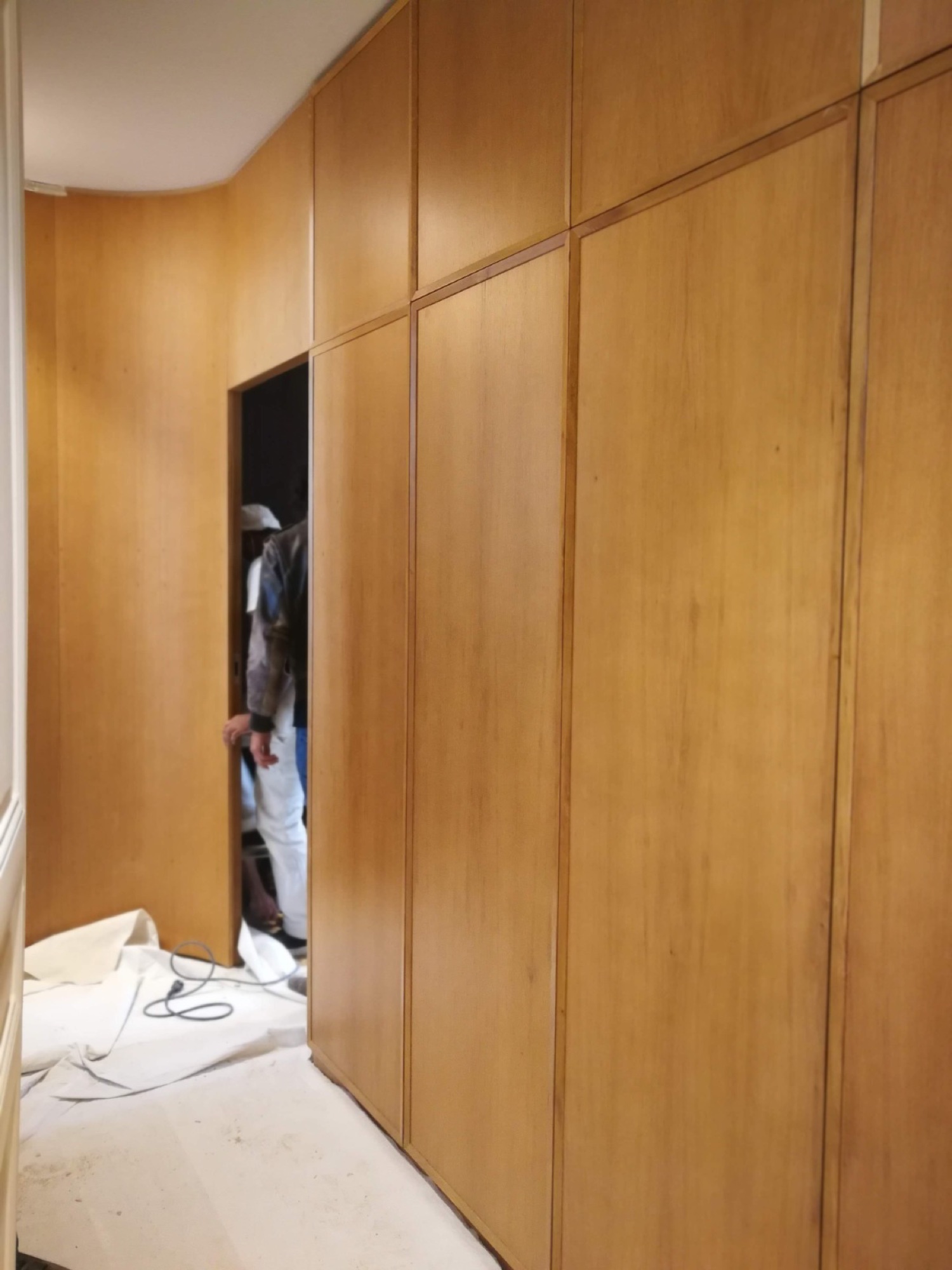 Parede revestida em painéis de madeira em instalação