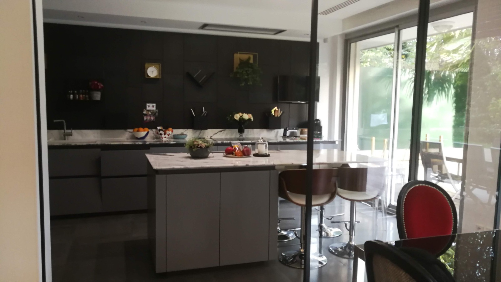 Cozinha preta aberta com ilha e bancos