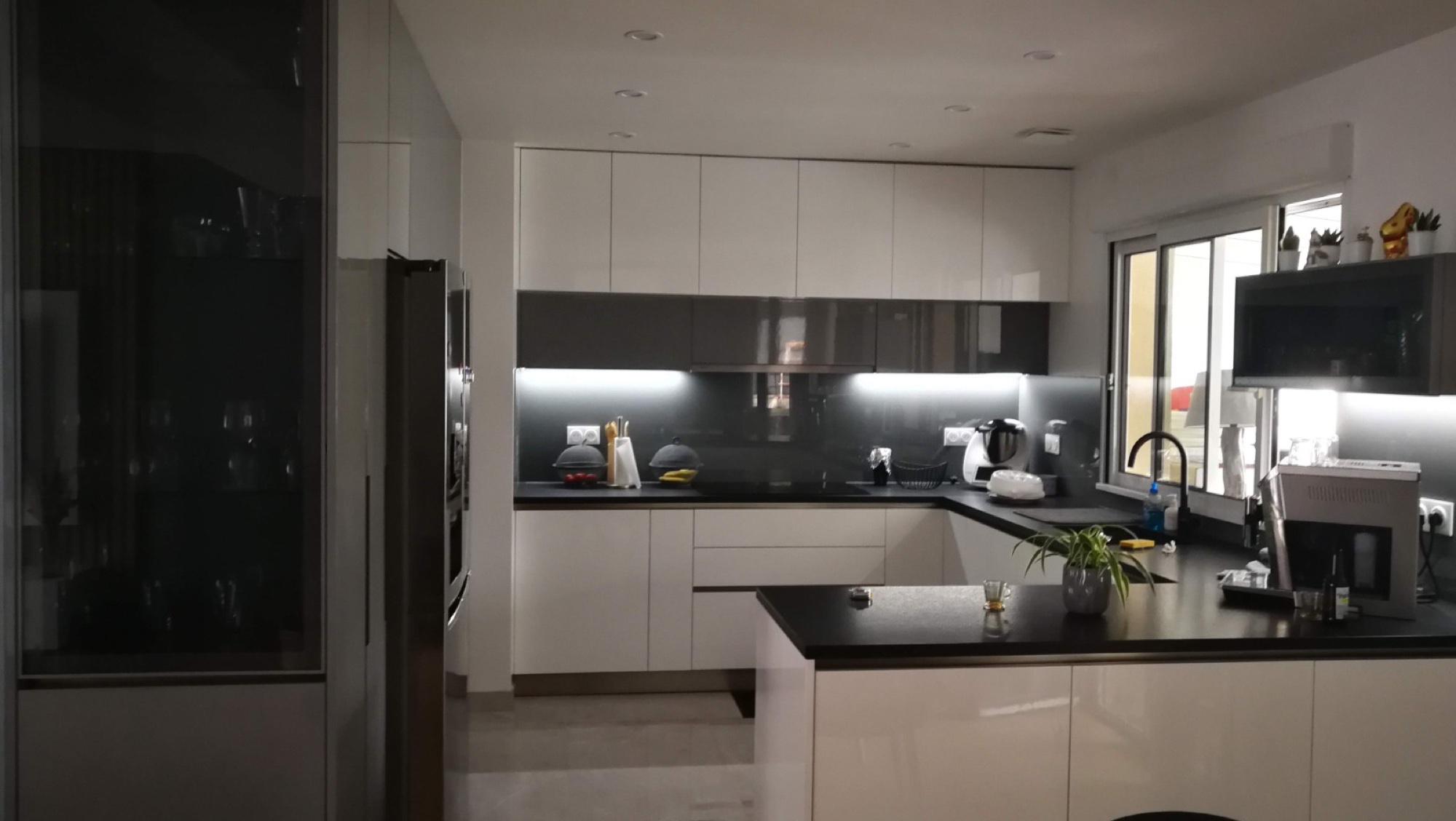 Cozinha branca em U com bancada preta