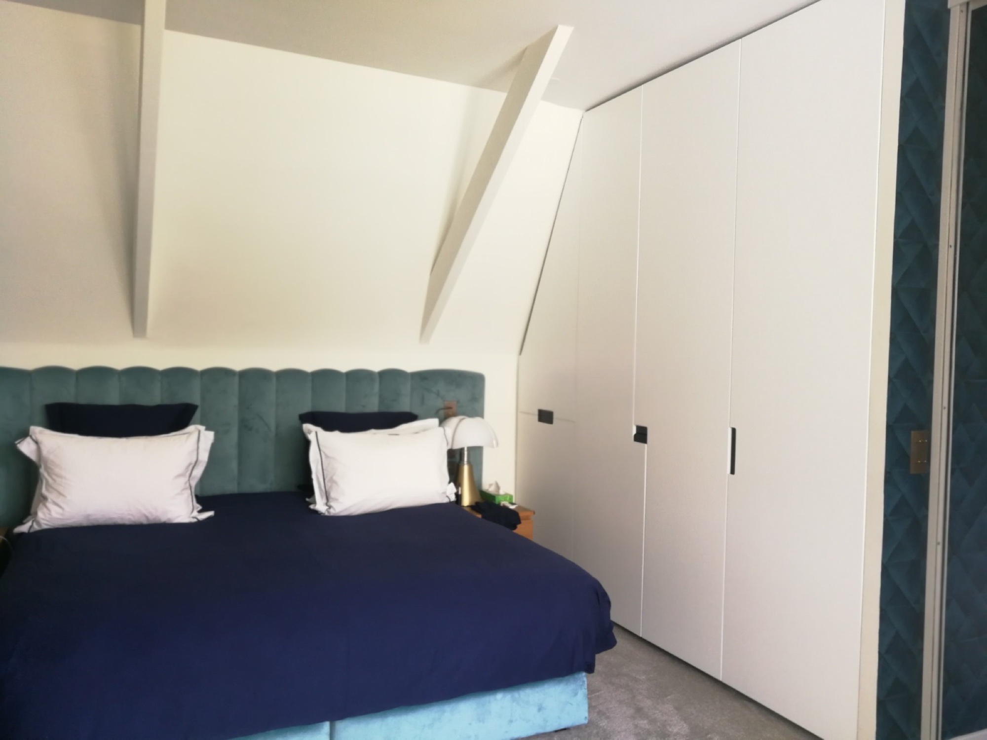 Quarto com cabeceira verde e roupeiro branco