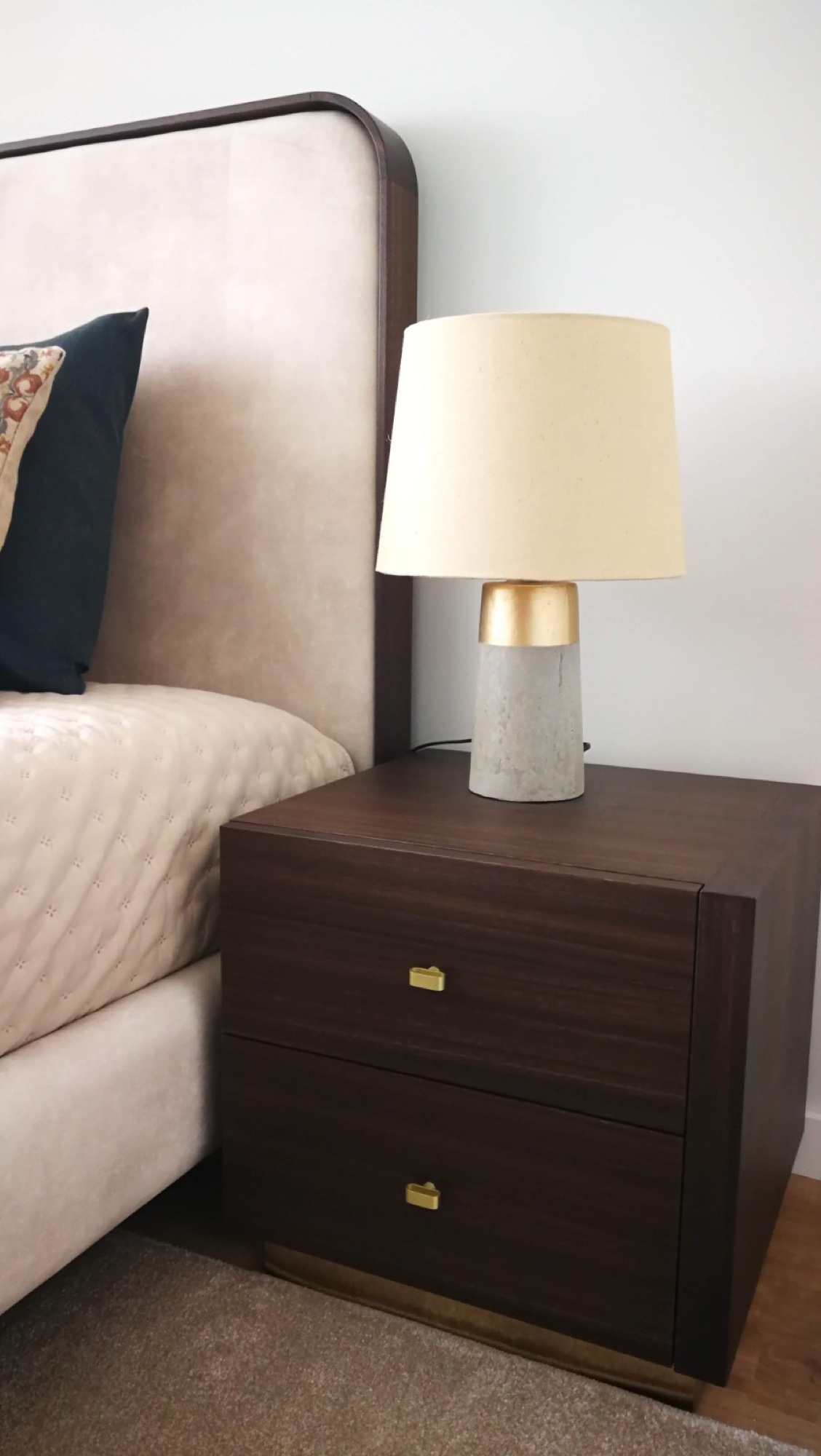 Mesa de cabeceira escura com candeeiro