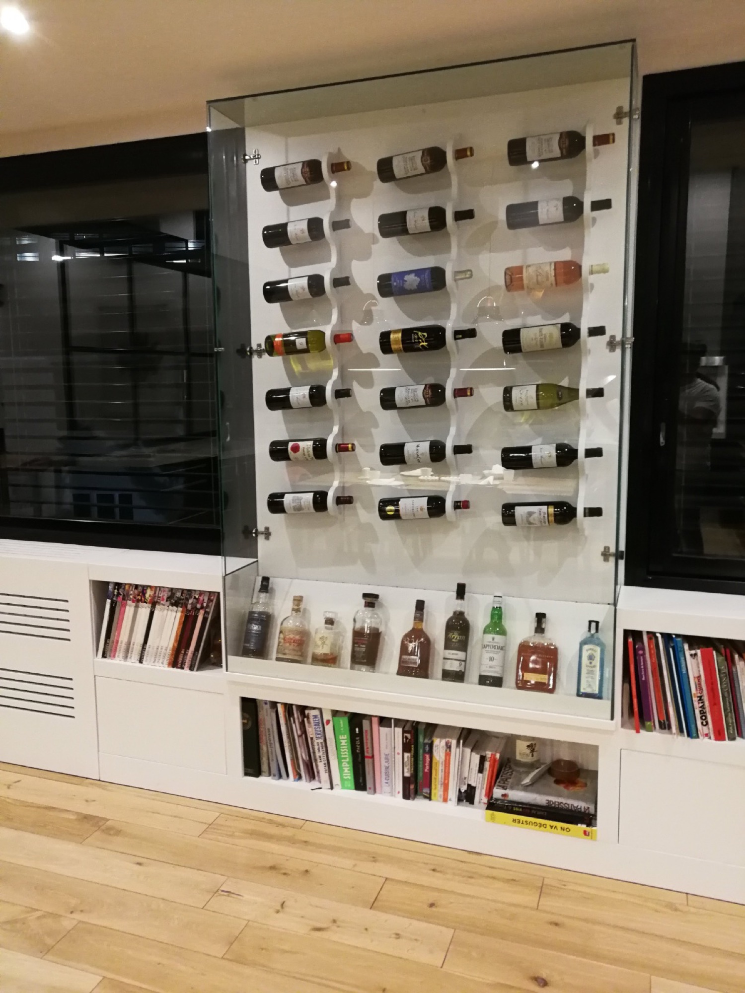 Garrafeira em vidro com estantes de livros