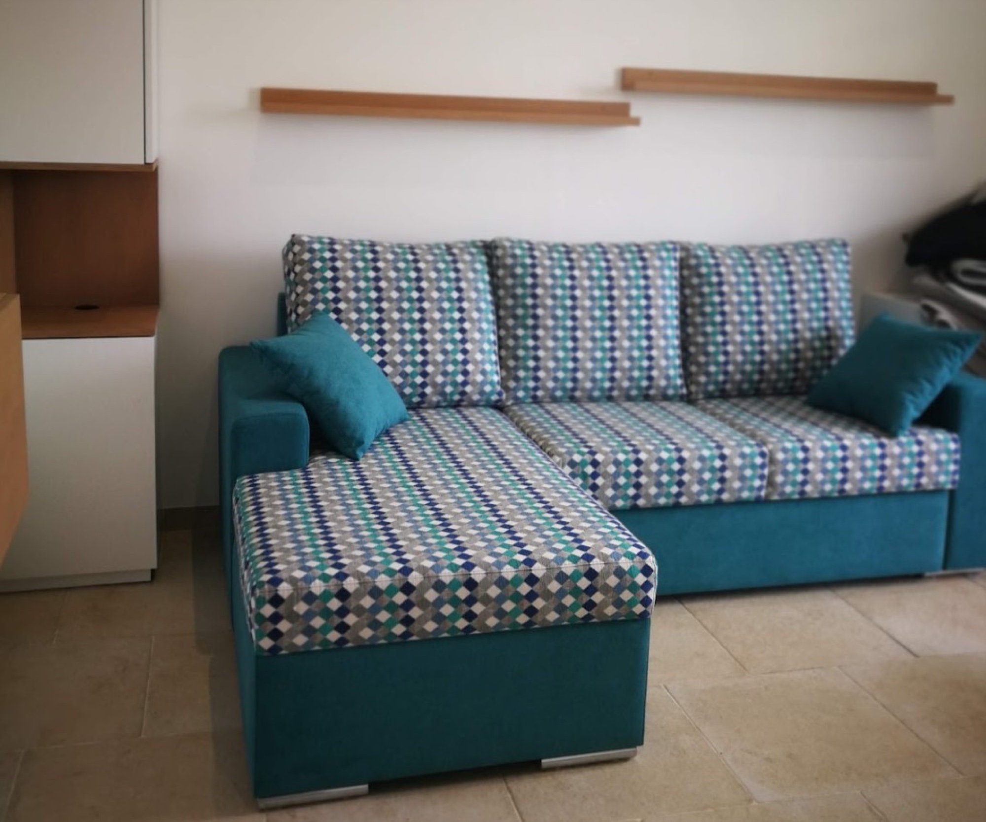 Sofá de canto turquesa com padrão geométrico