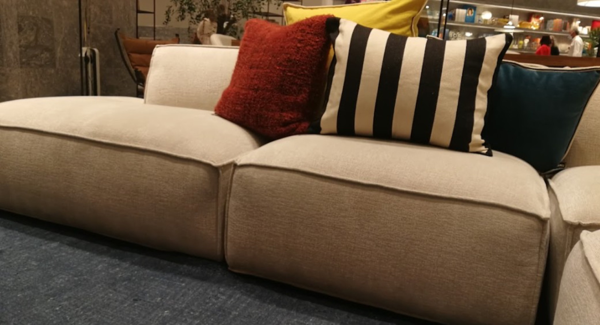 Sofá bege com almofadas decorativas coloridas