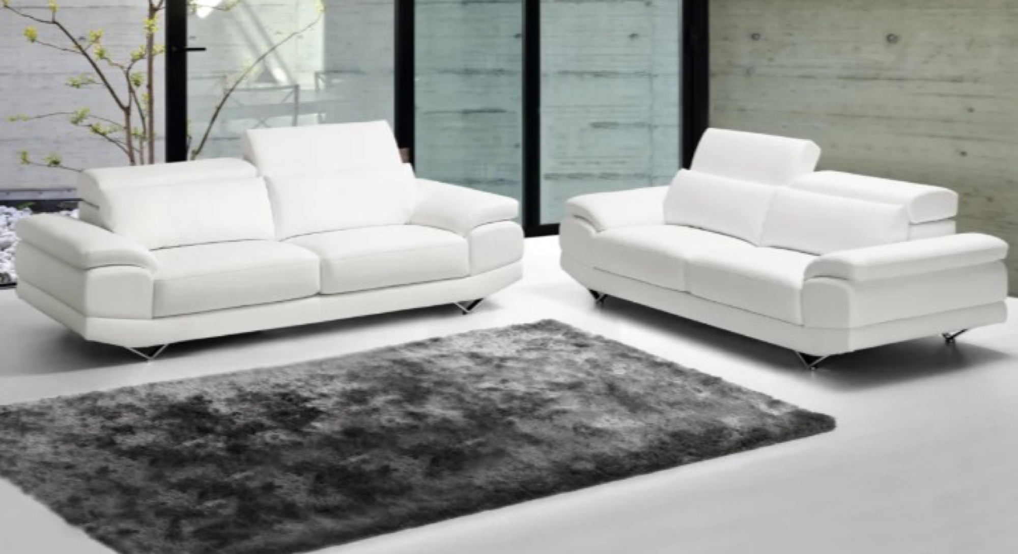 Dois sofás brancos em couro com tapete cinzento