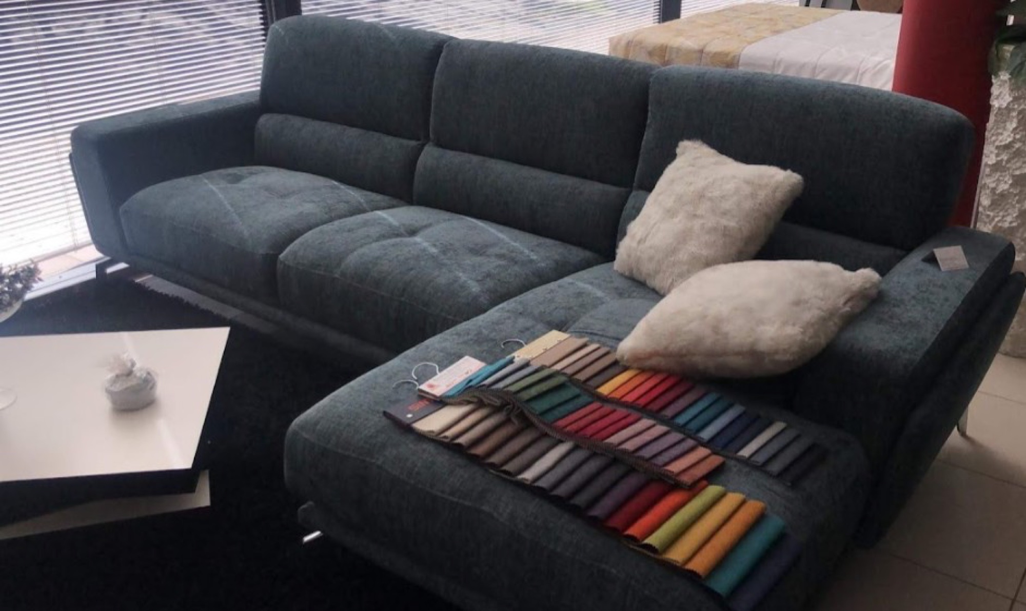 Sofá de canto verde escuro com amostras de cores