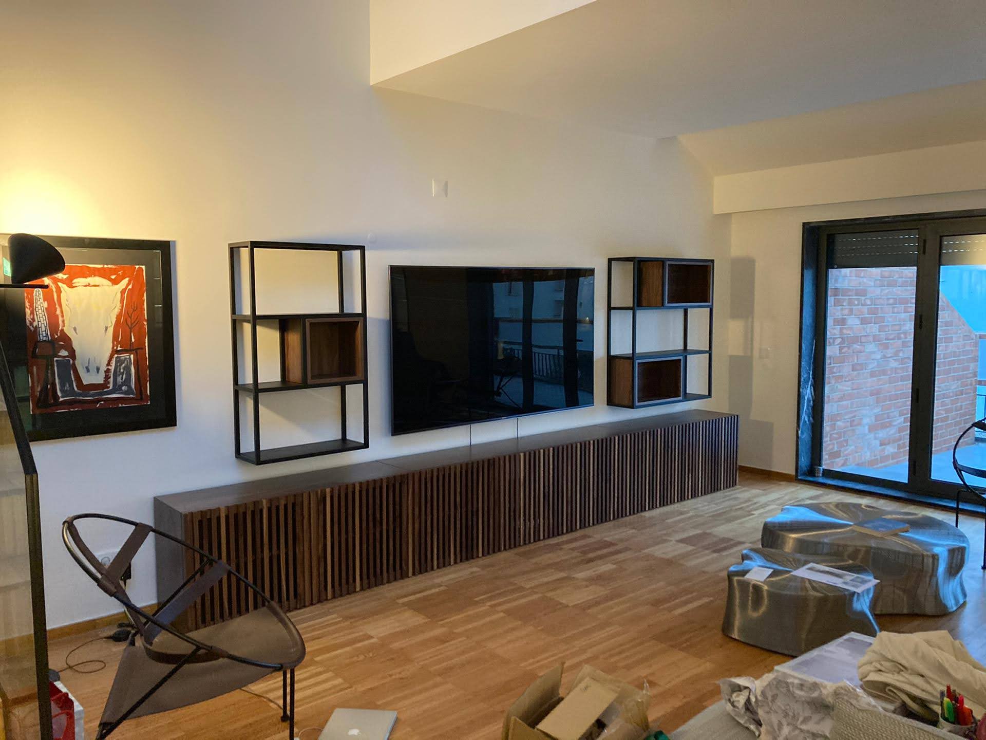 Movel de TV em ripado de madeira escura, estantes metalicas com detalhes em madeira e quadro abstrato