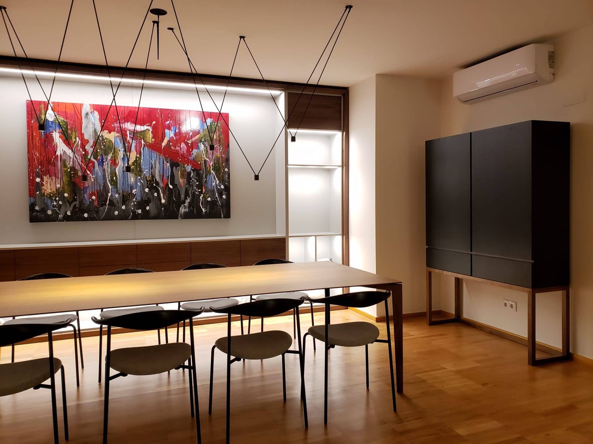 Sala de jantar com estante iluminada, aparador alto em lacado escuro com base em madeira