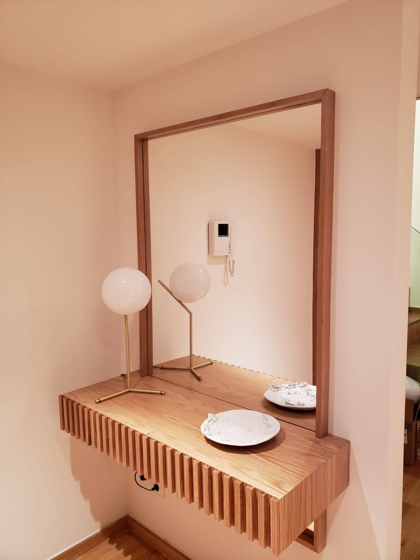 Consola suspensa em carvalho com ripado vertical, espelho com moldura em madeira e candeeiro dourado