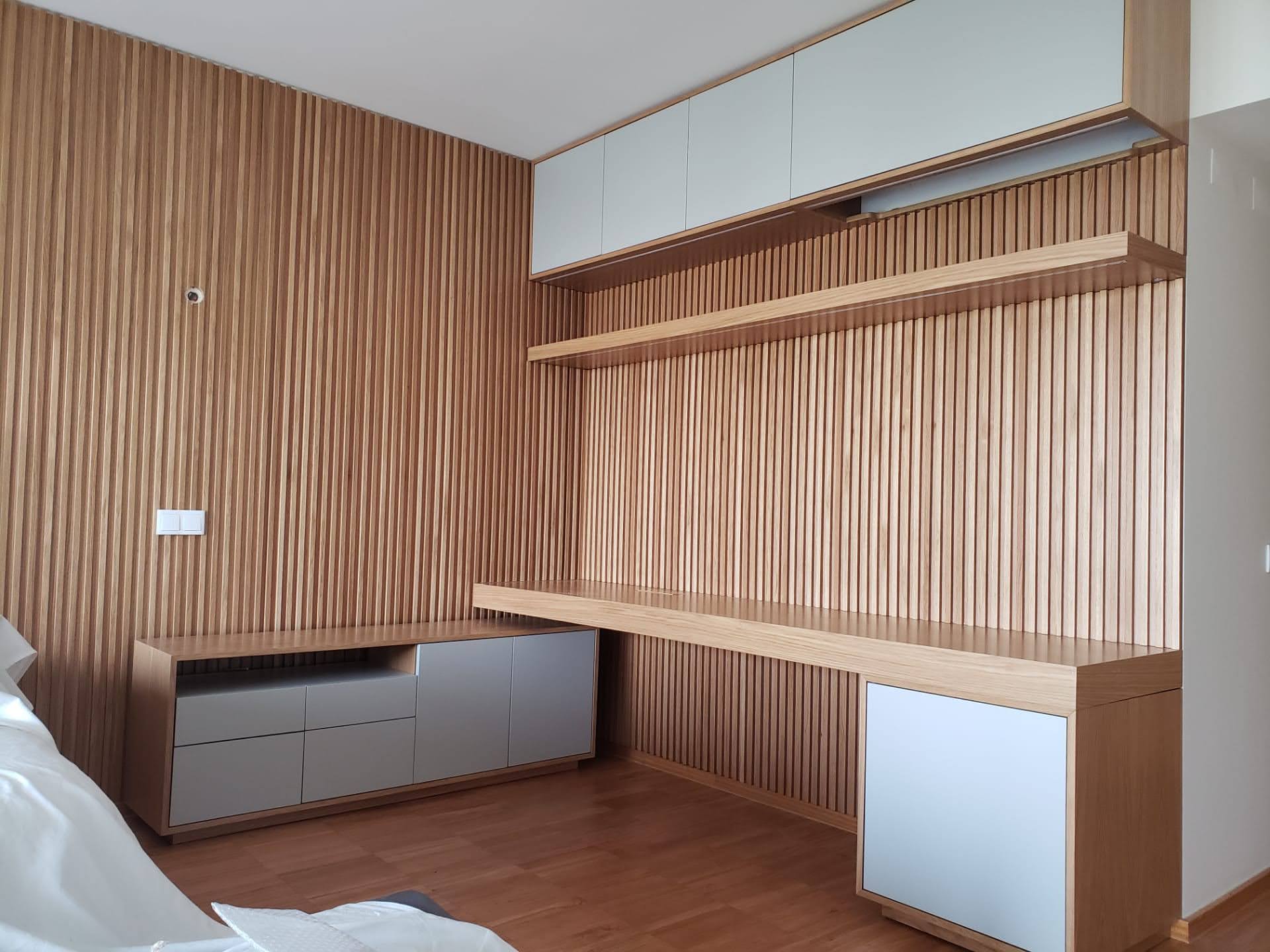 Quarto com parede em ripado de carvalho, secretaria em L com gavetas lacadas e armarios superiores