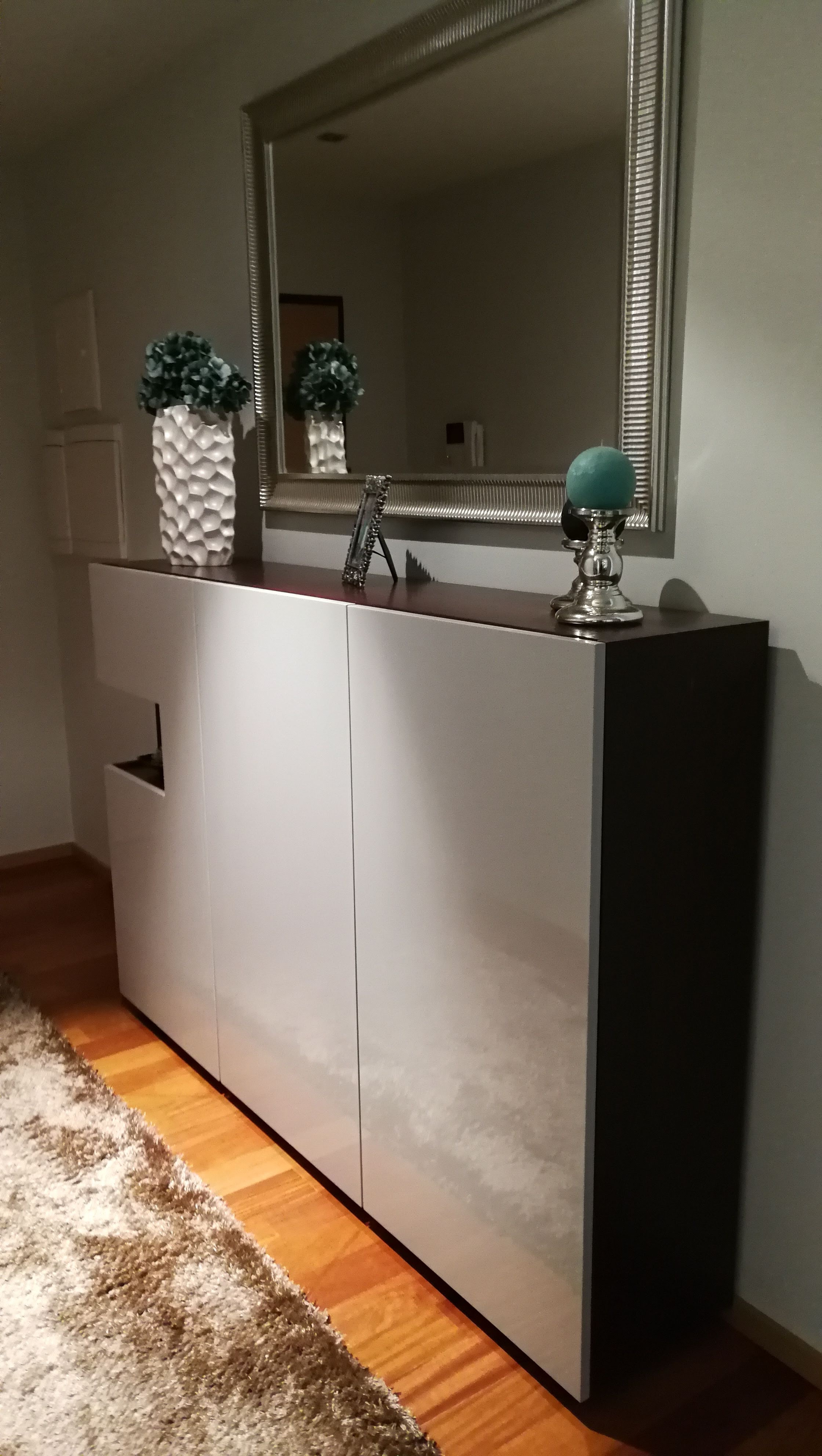 Hall com aparador suspenso em lacado branco e madeira escura, espelho grande e candeeiro turquesa