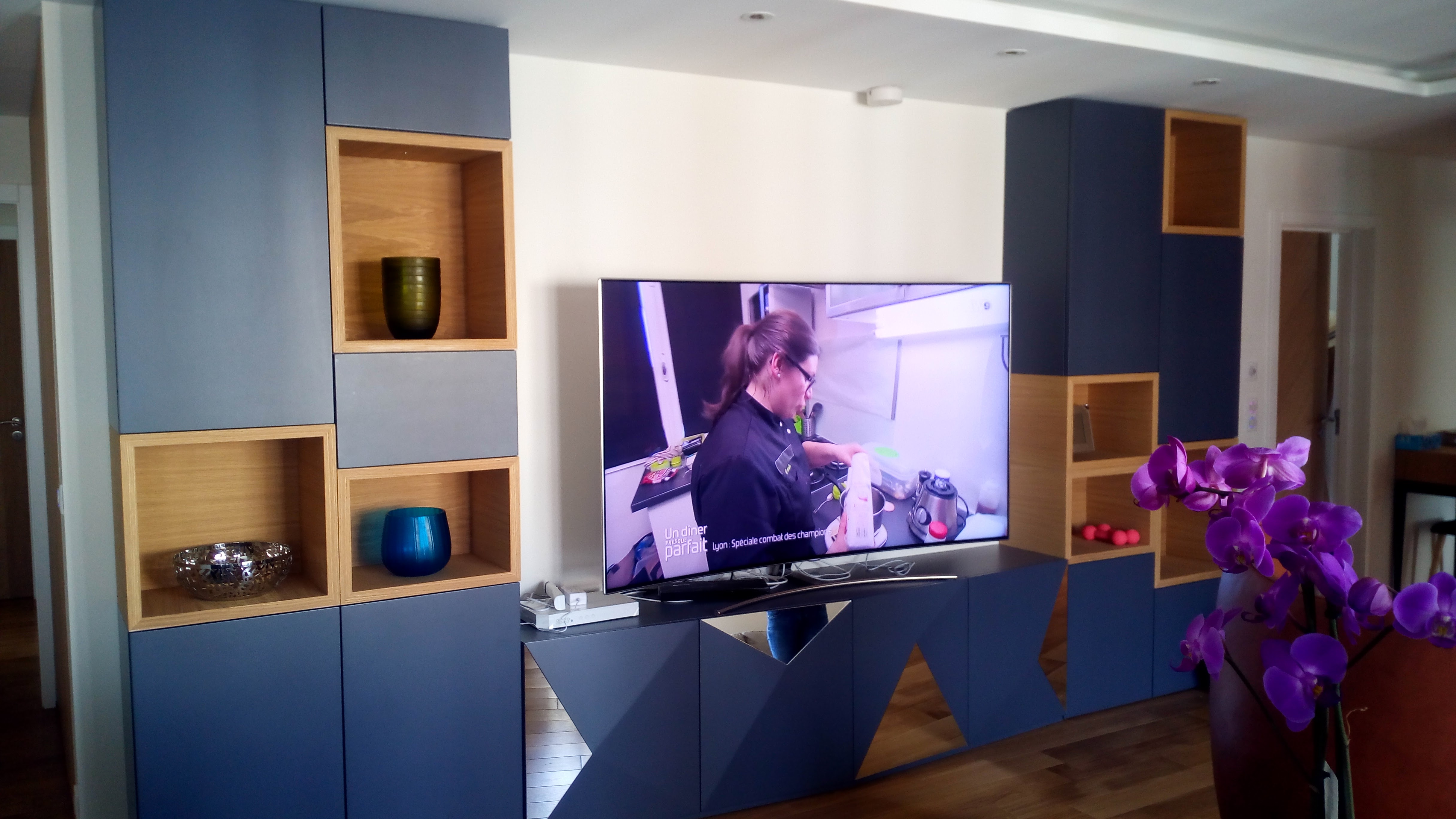 Movel de TV em lacado azul-marinho com nichos em carvalho natural e televisao grande