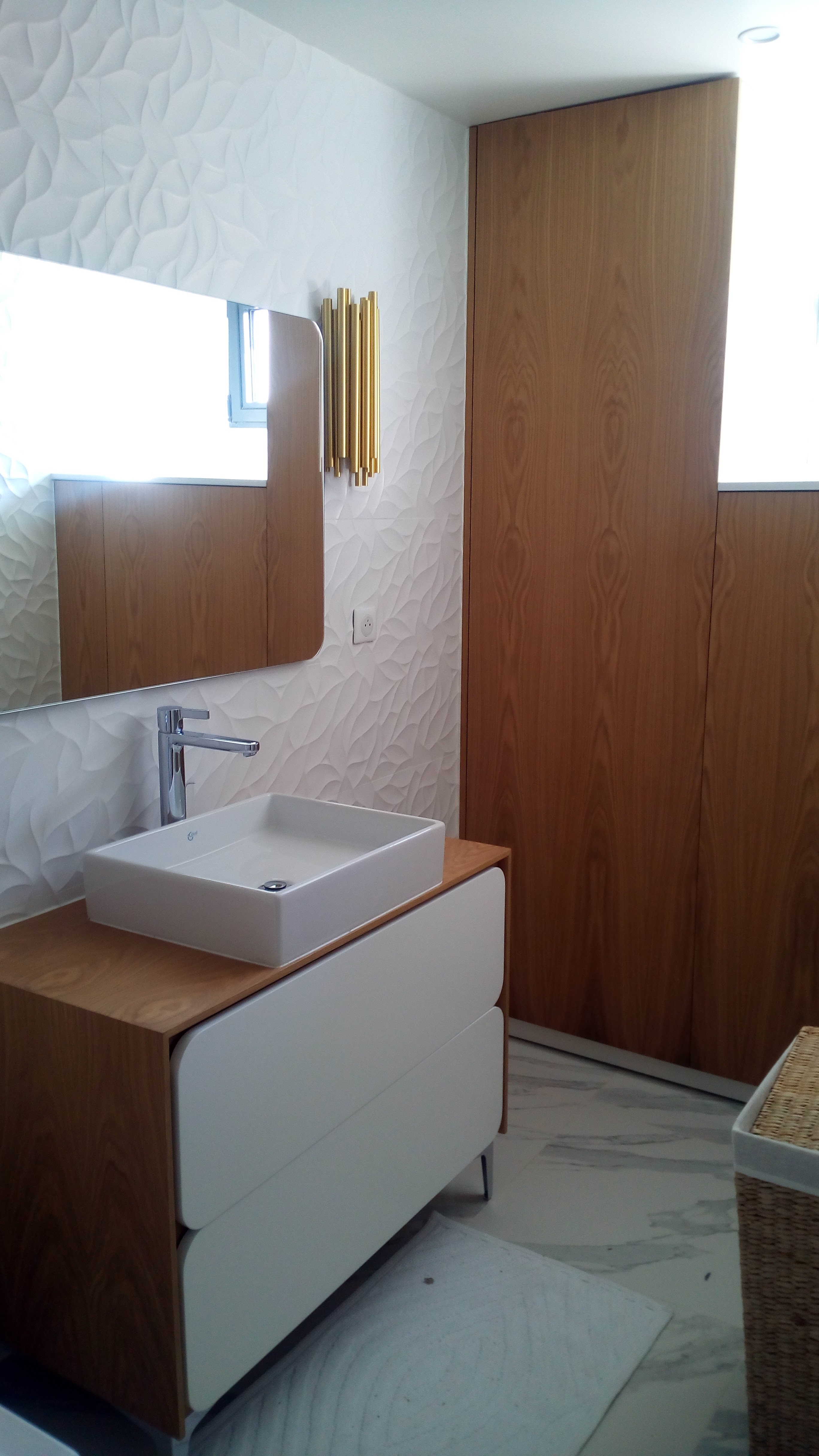 Casa de banho com movel em carvalho e gavetas brancas, revestimento tridimensional branco e aplique dourado