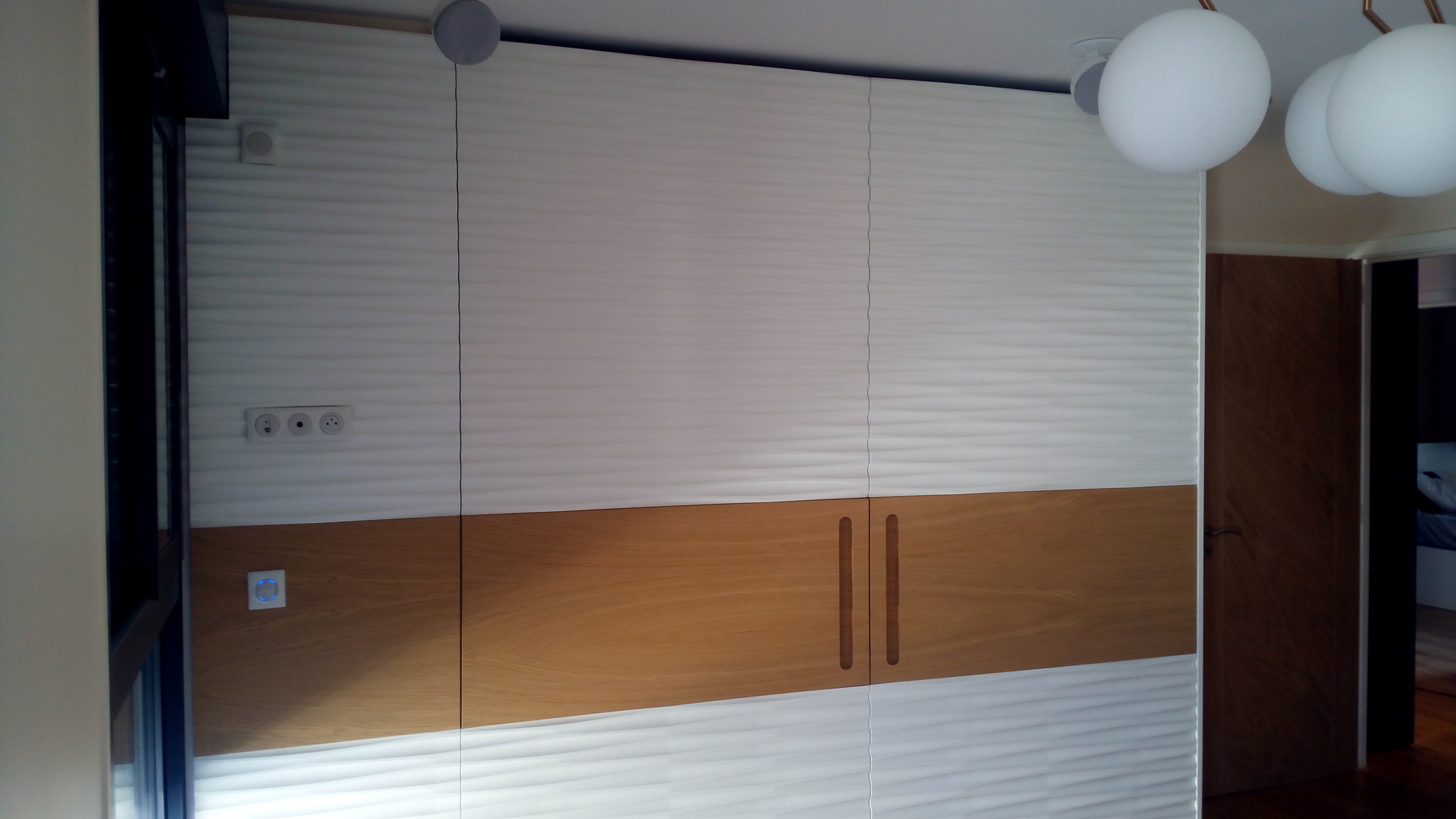 Roupeiro grande com textura ondulada branca e faixa em carvalho, candeeiros esfericos suspensos