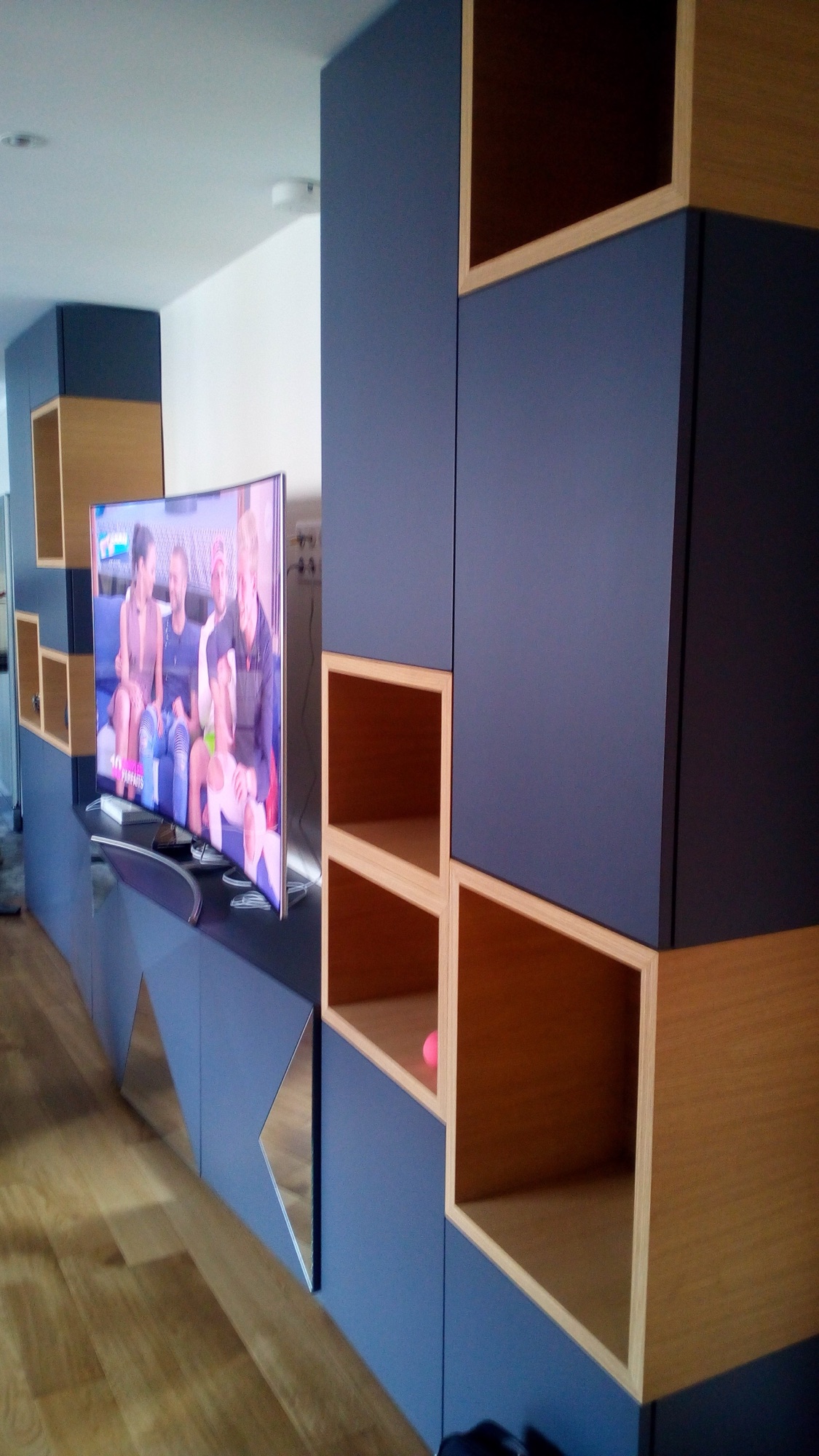 Movel de TV em lacado azul-marinho com nichos em carvalho, base com recortes em espelho