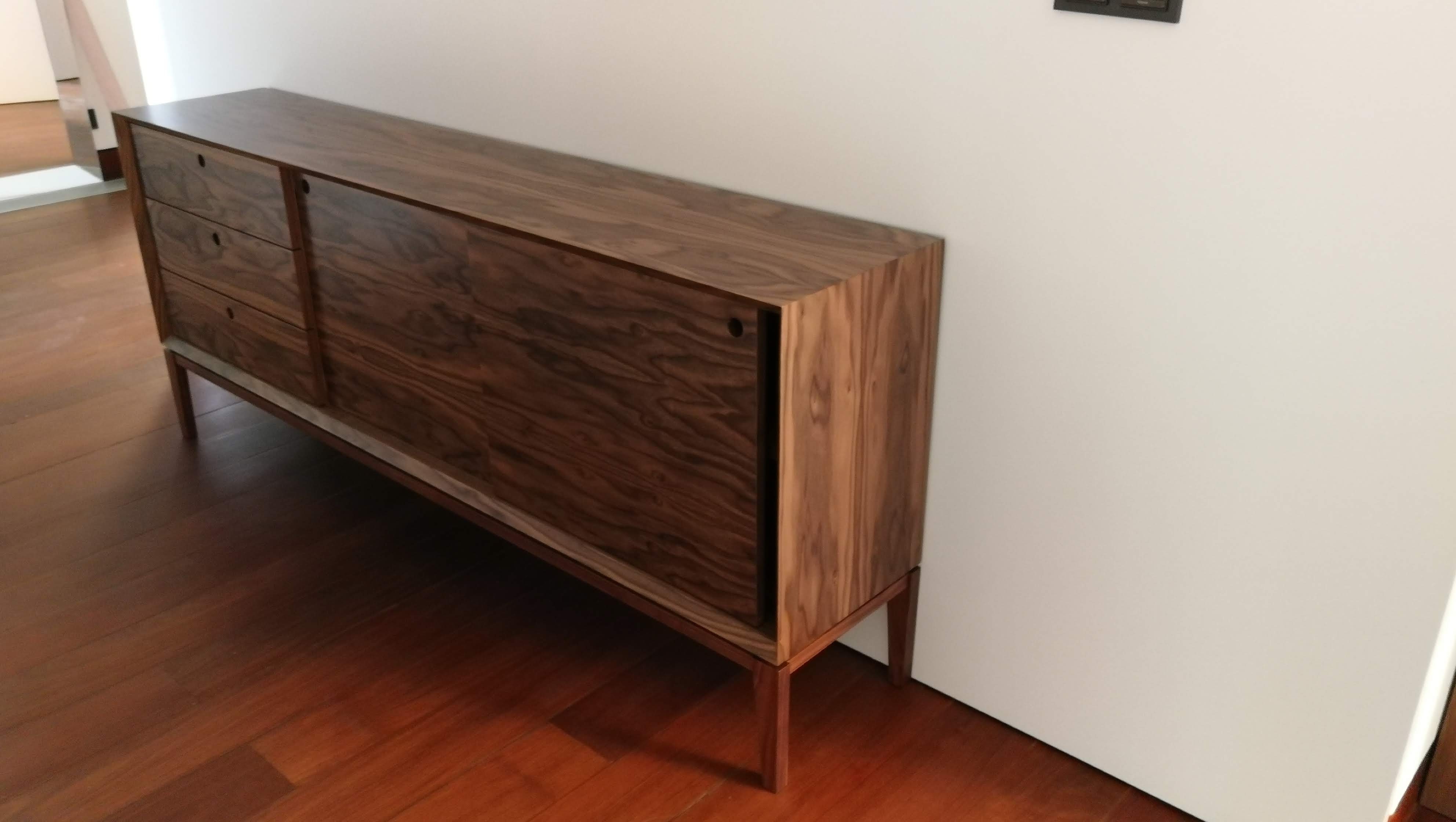 Aparador de hall em madeira macica de nogueira com gavetas e porta sobre pes altos