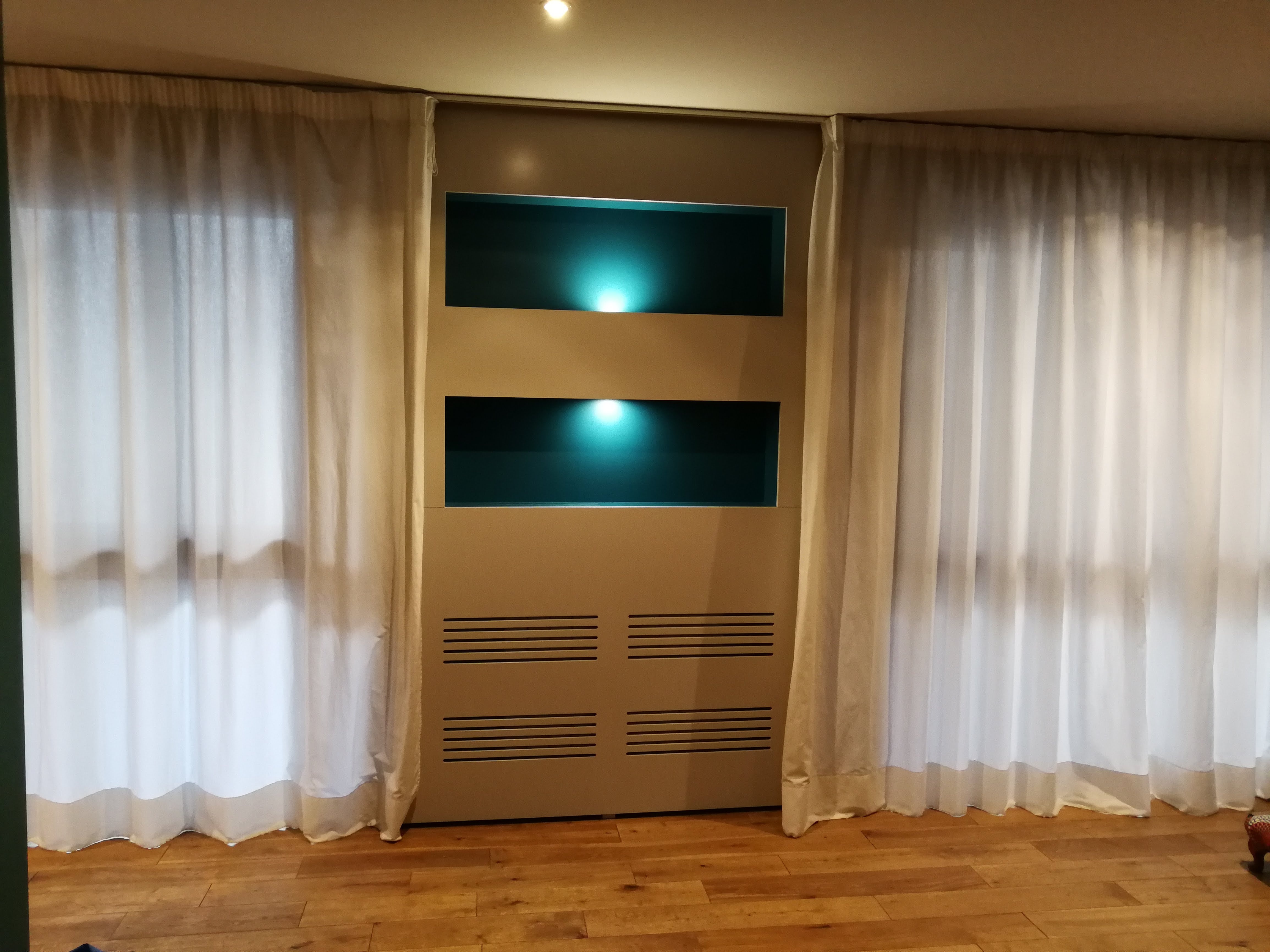 Vista frontal do movel com nichos azul turquesa, grelhas de ventilacao e cortinas