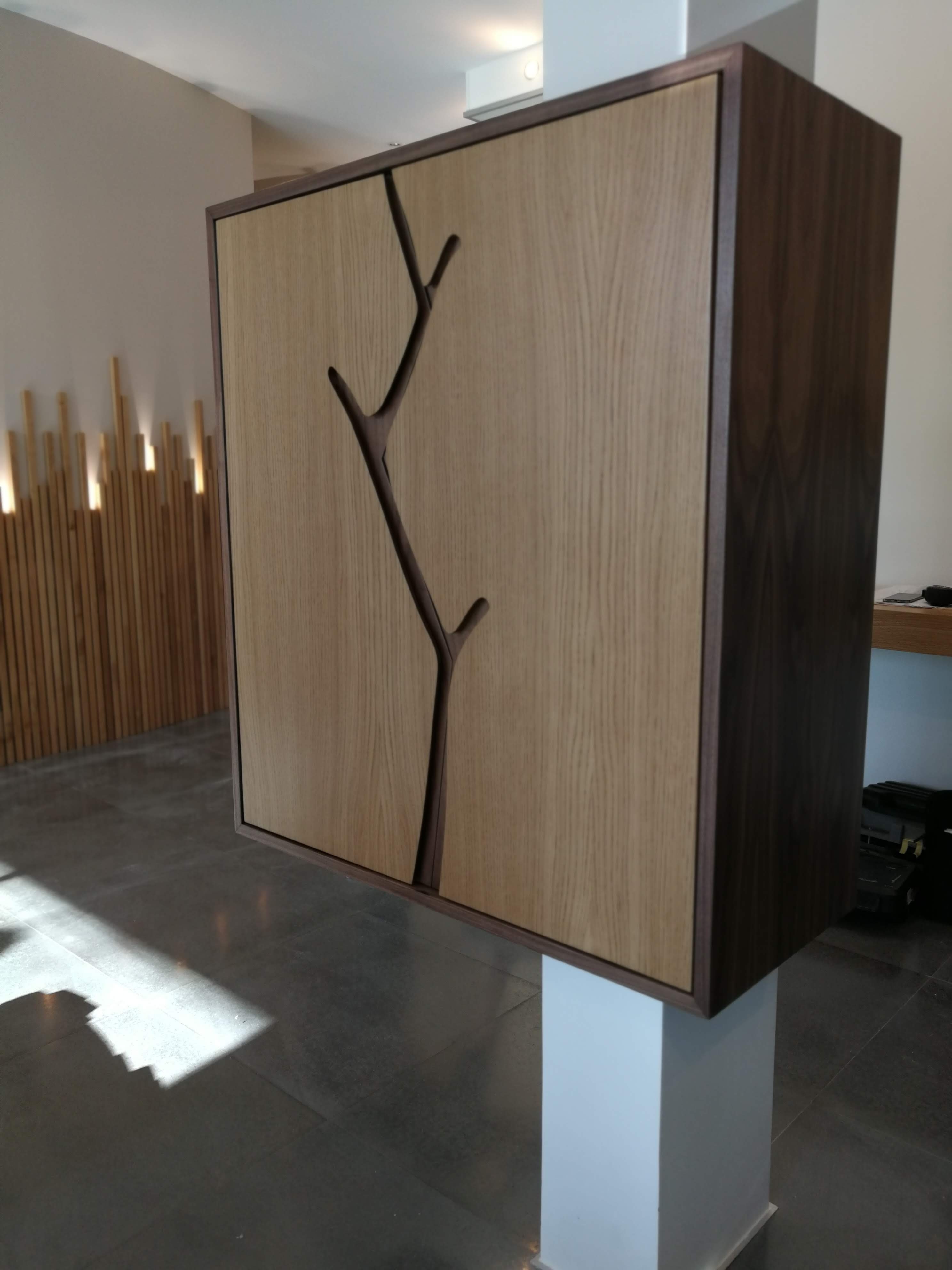Armario de hall com porta em carvalho decorada com motivo escultural de ramo de arvore em nogueira