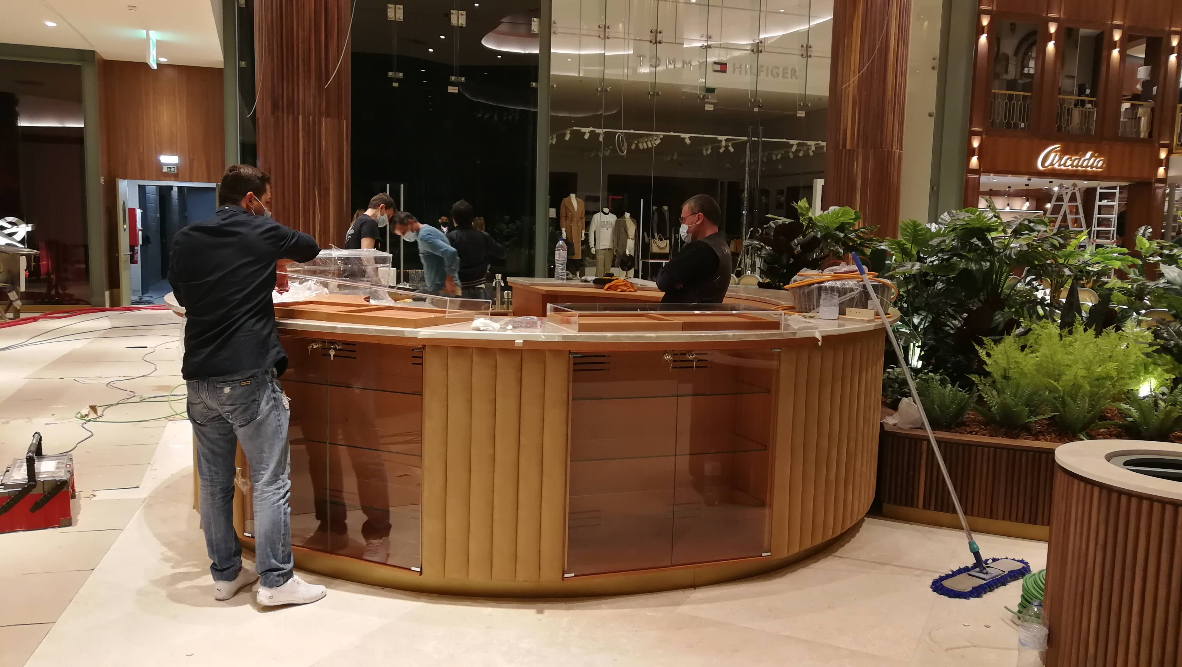 Vista panoramica do quiosque durante a instalacao, com equipa a finalizar os acabamentos no centro comercial