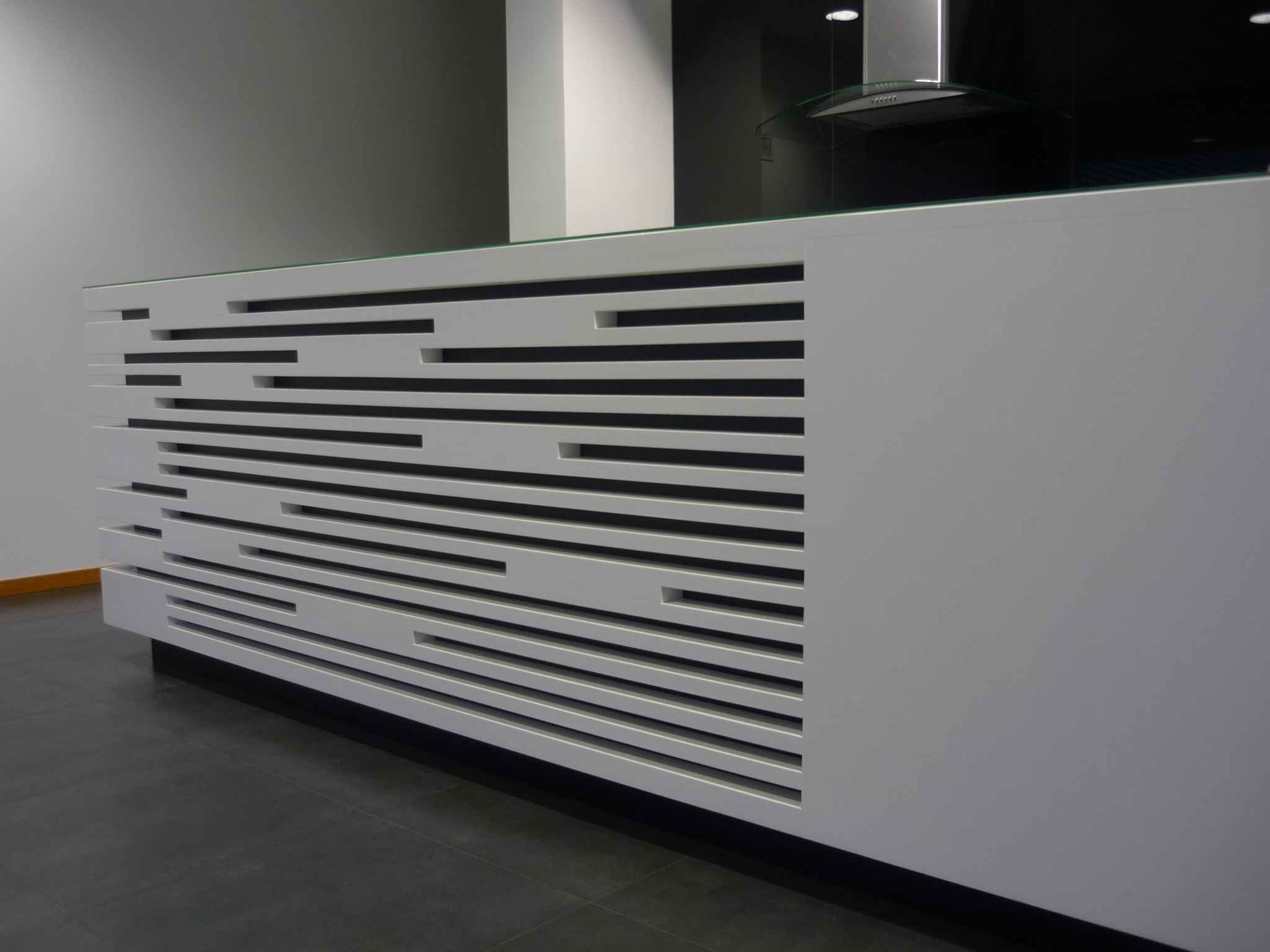 Painel frontal do balcao com ritmo de ripas horizontais de espessuras variadas