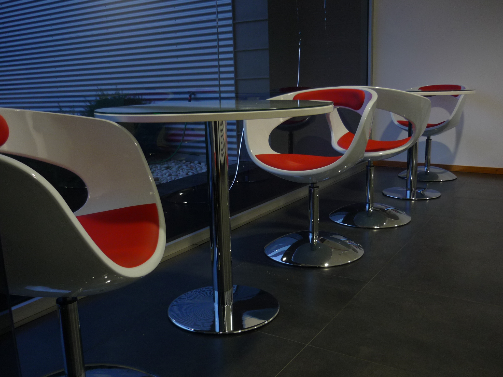 Zona de reunioes com cadeiras de design e mesas em vidro cromado