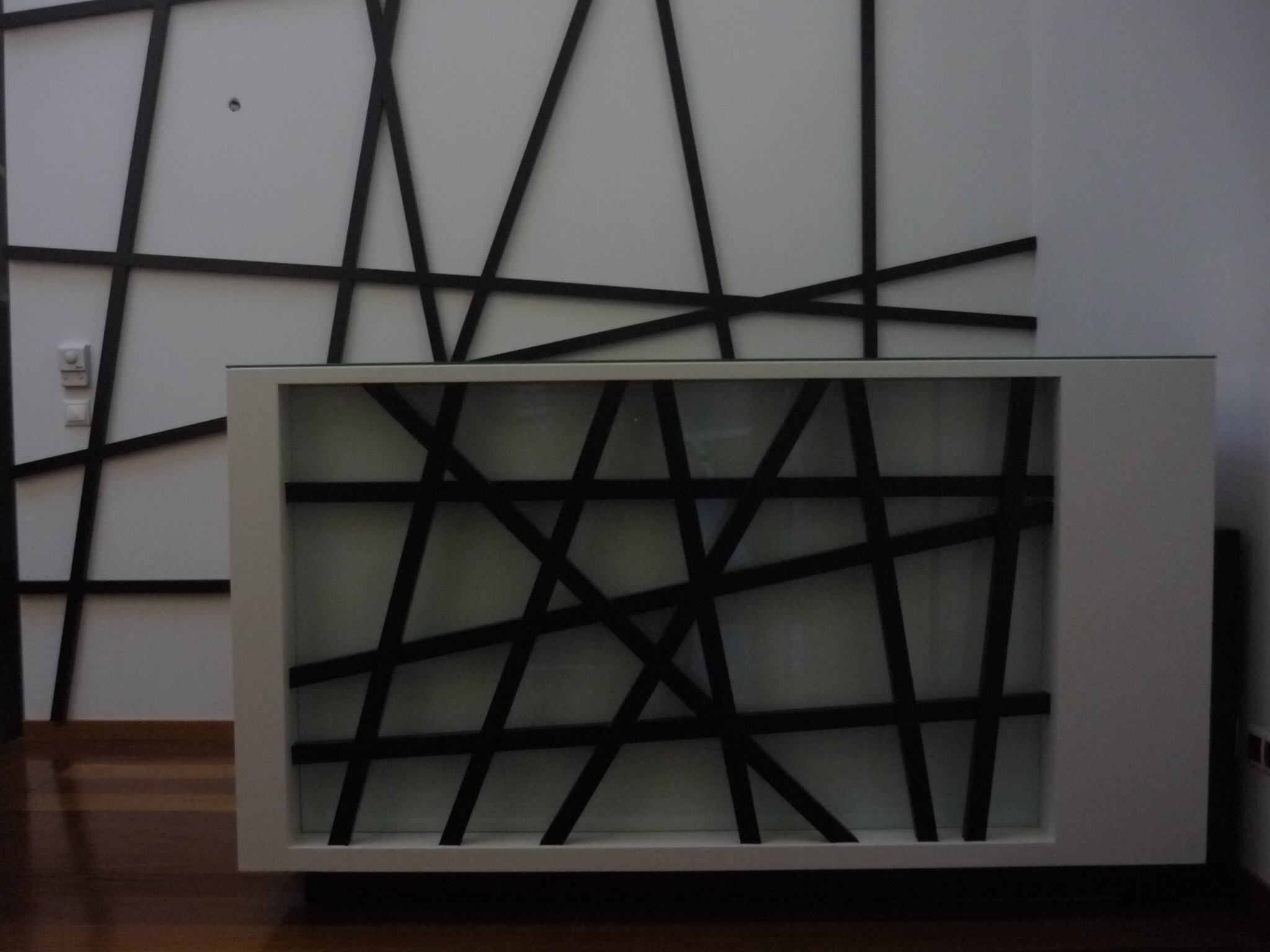 Parede de destaque com composicao geometrica em ripas escuras sobre fundo claro