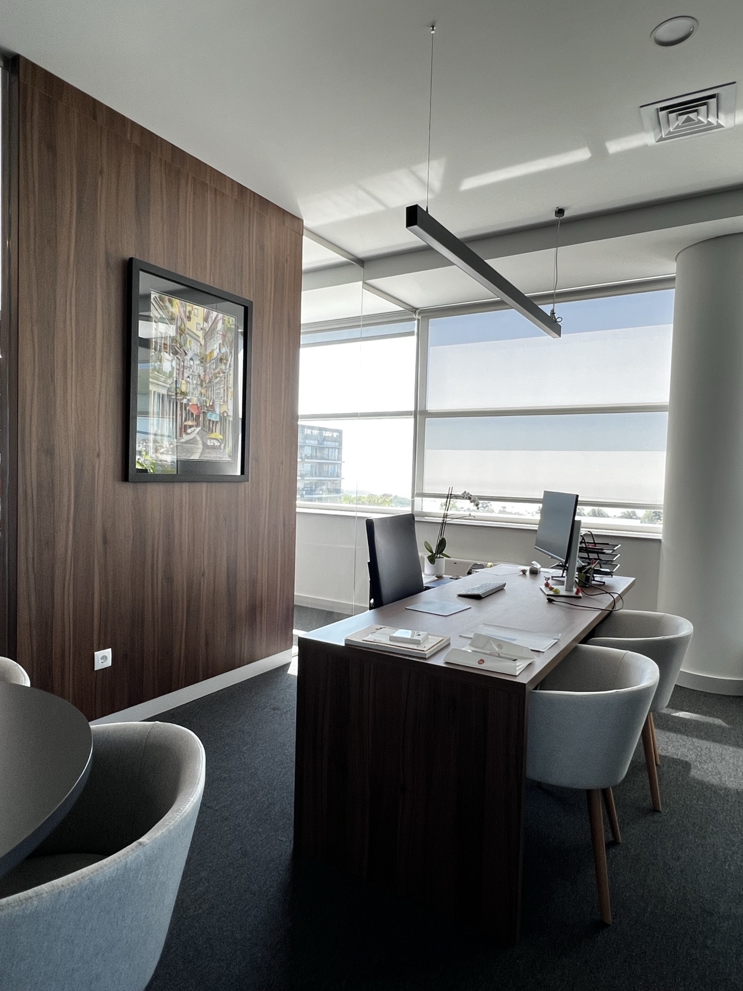Sala de direcao com secretaria em nogueira, modulo suspenso lacado branco e poltronas de reuniao