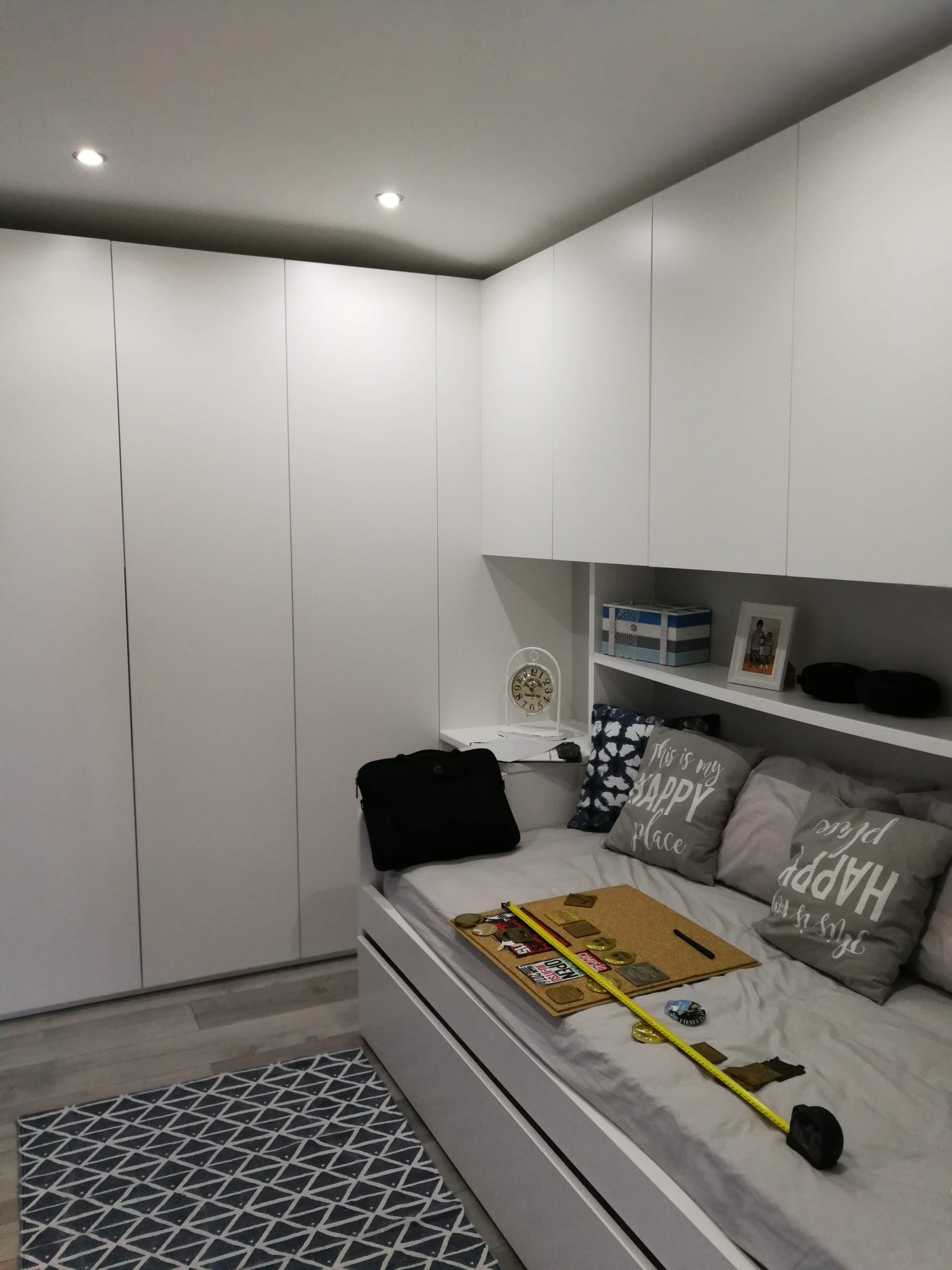 Vista geral com armario embutido, cama com gaveta e prateleiras de cabeceira