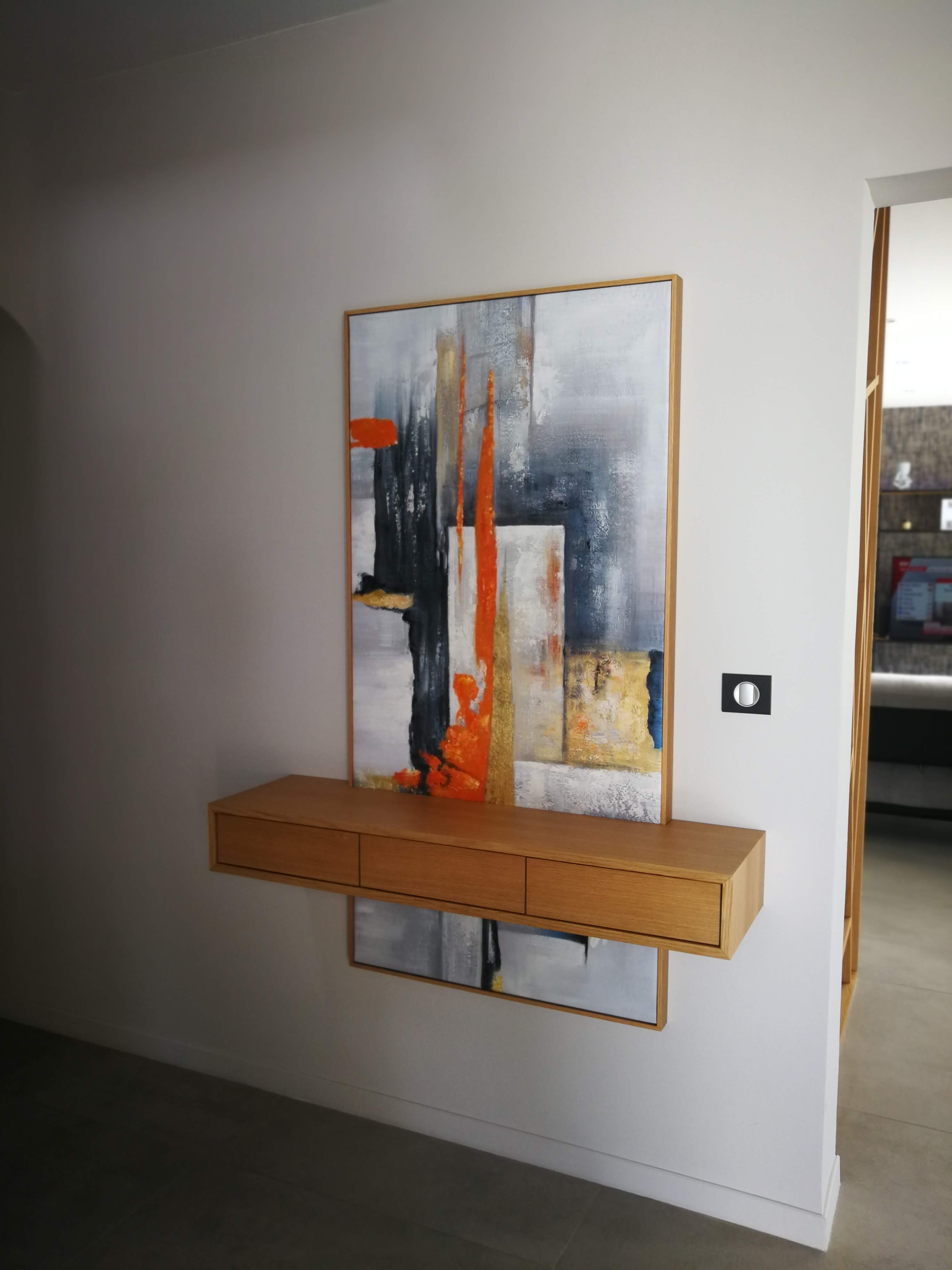 Hall com consola suspensa em carvalho e quadro abstrato em tons de laranja, cinza e preto