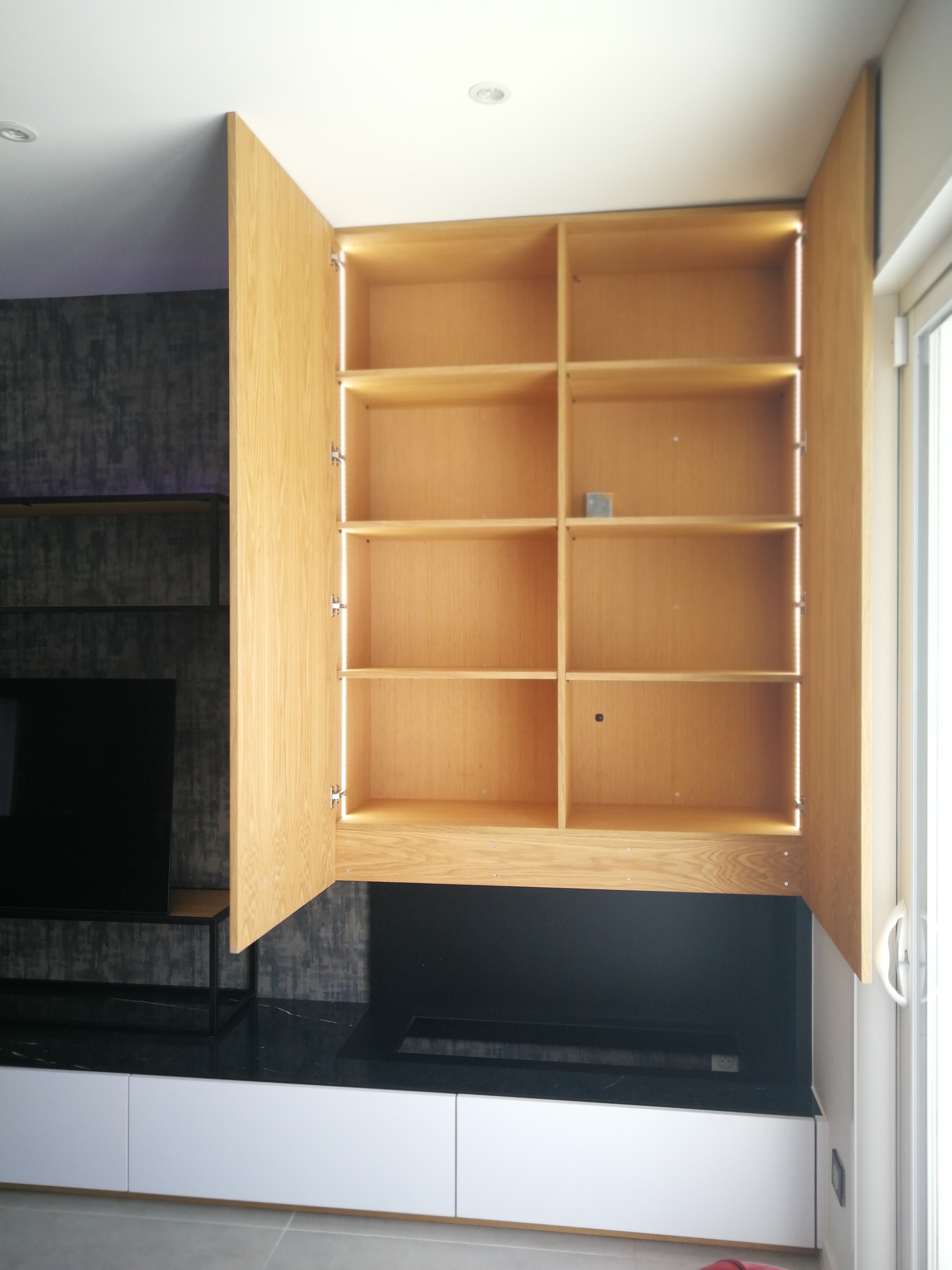 Armario alto em carvalho com portas abertas revelando prateleiras iluminadas com LED