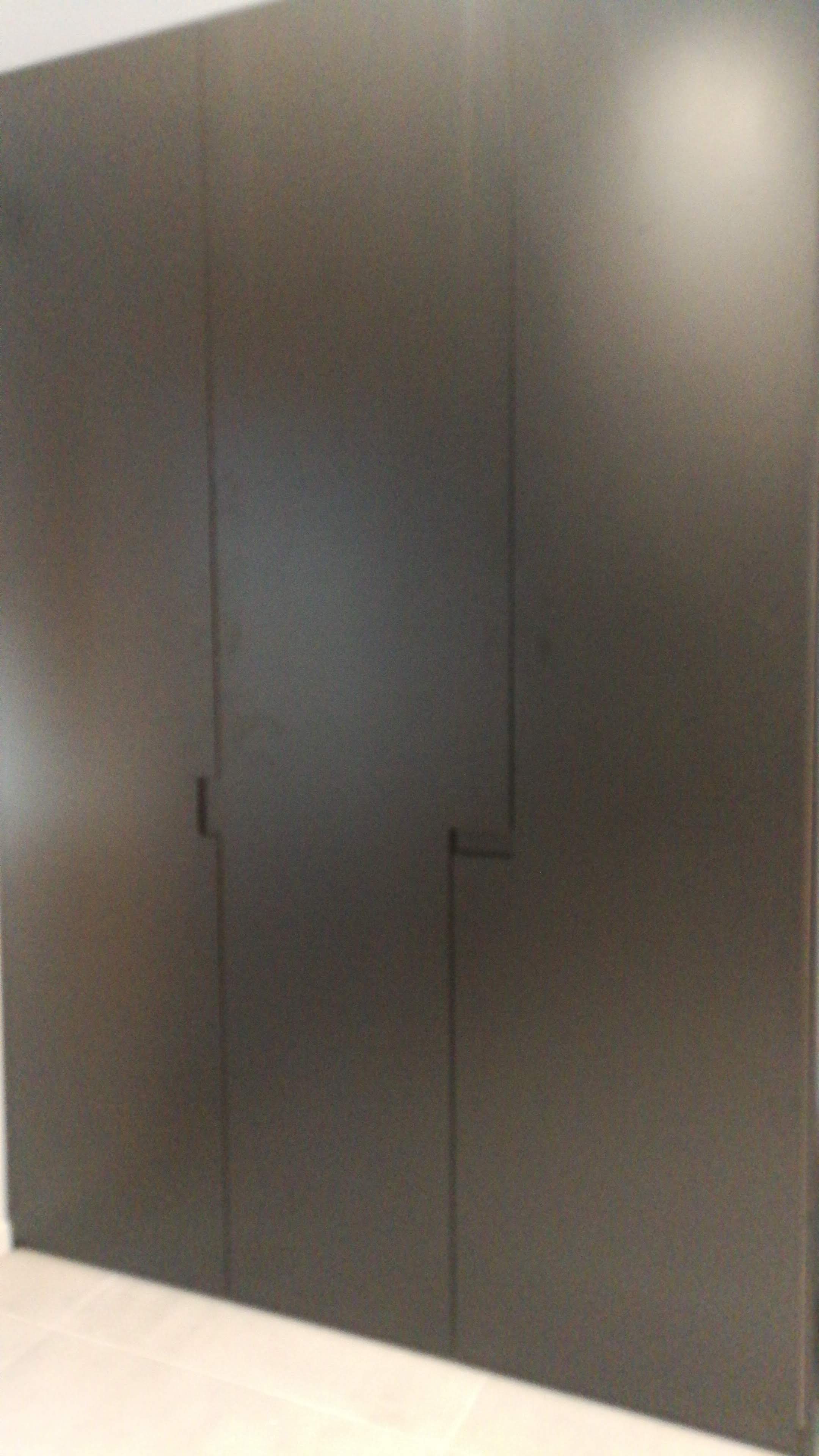 Armario de corredor com portas altas em preto mate e puxadores embutidos