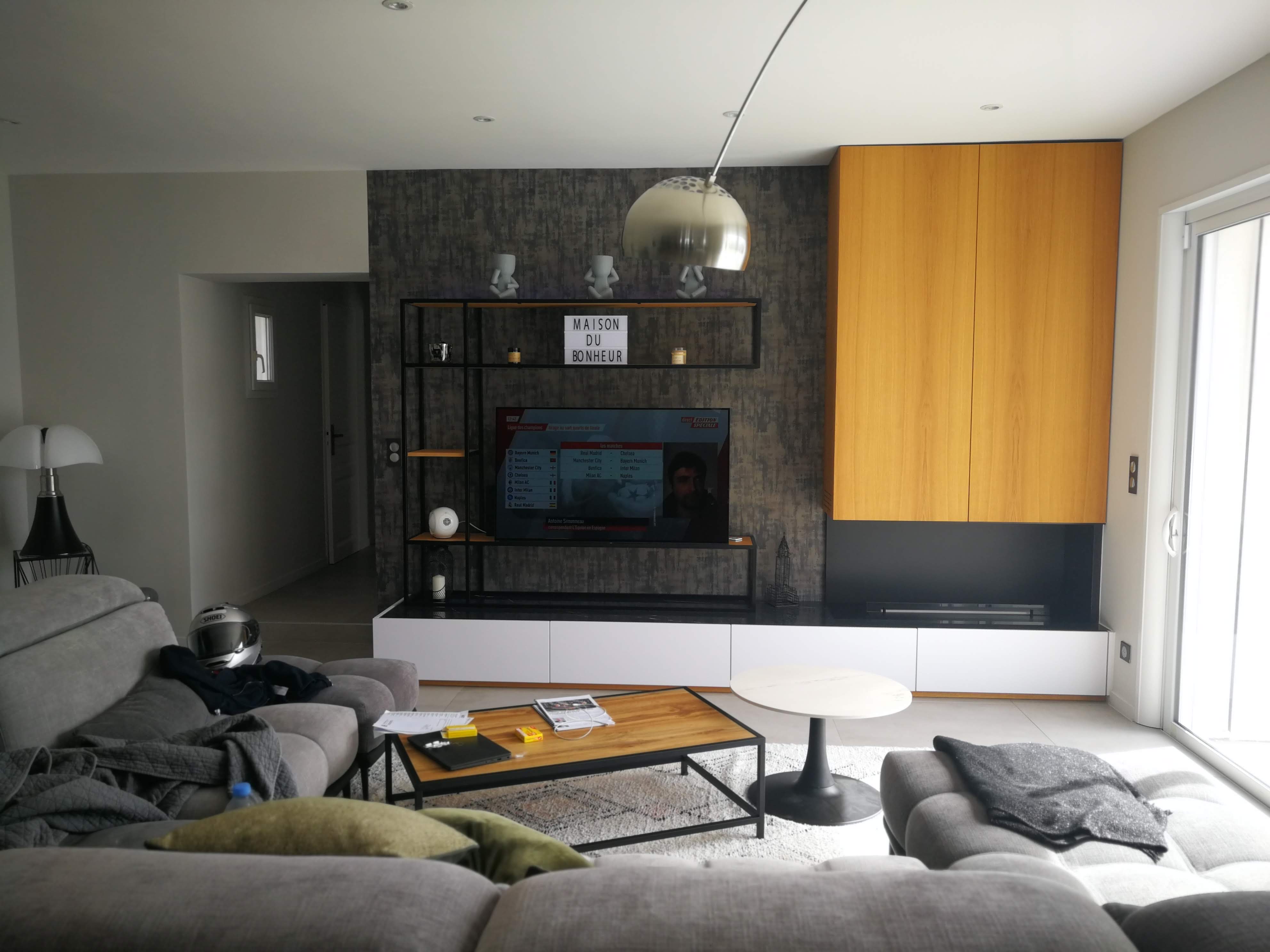 Sala com movel de TV branco e estante metalica preta, sofas cinza e candeeiro arco cromado