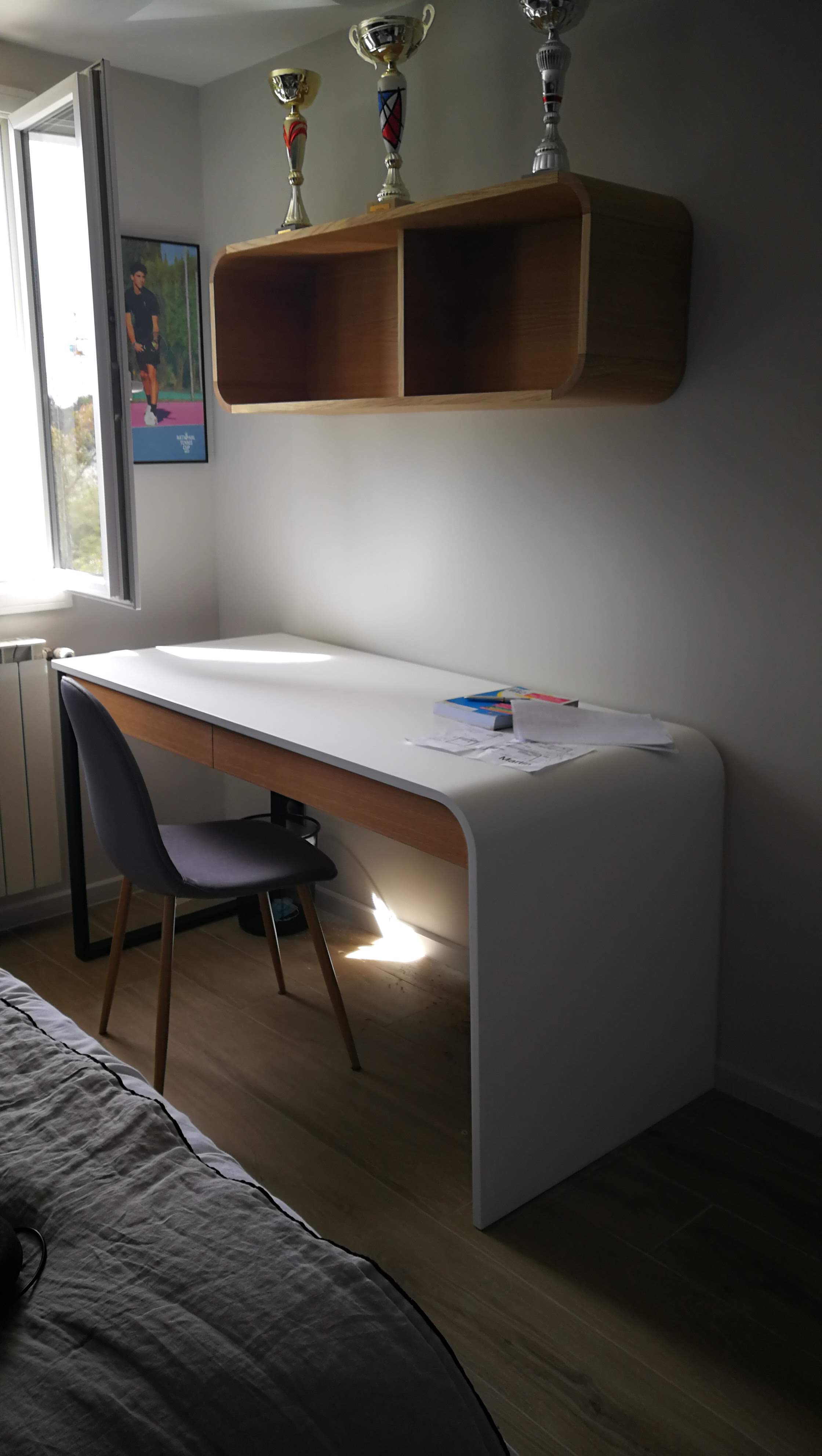 Quarto de adolescente com secretaria em branco e carvalho arredondado e prateleira com trofeus