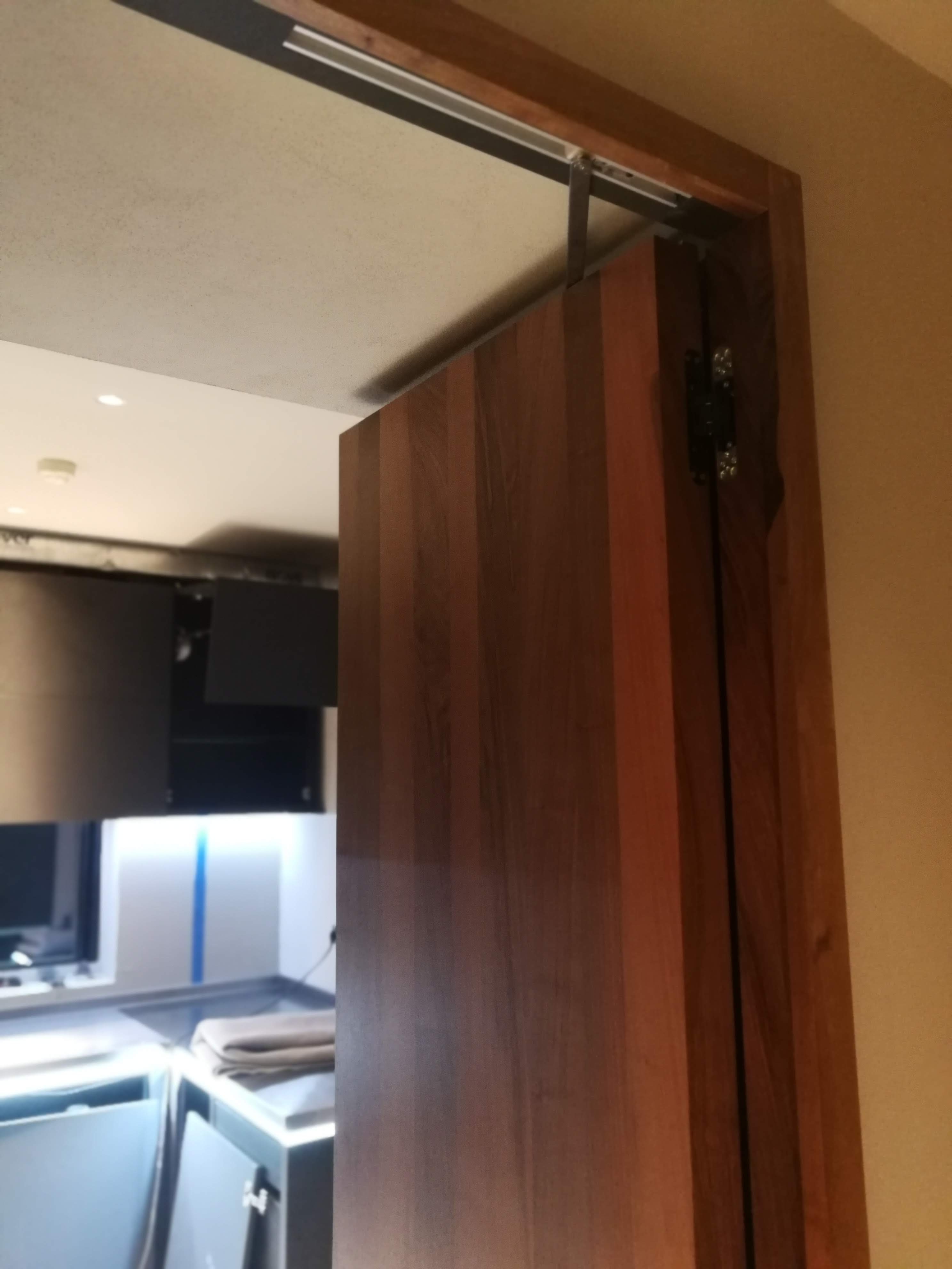 Porta de correr em nogueira com ferragem superior, abertura para zona de cozinha