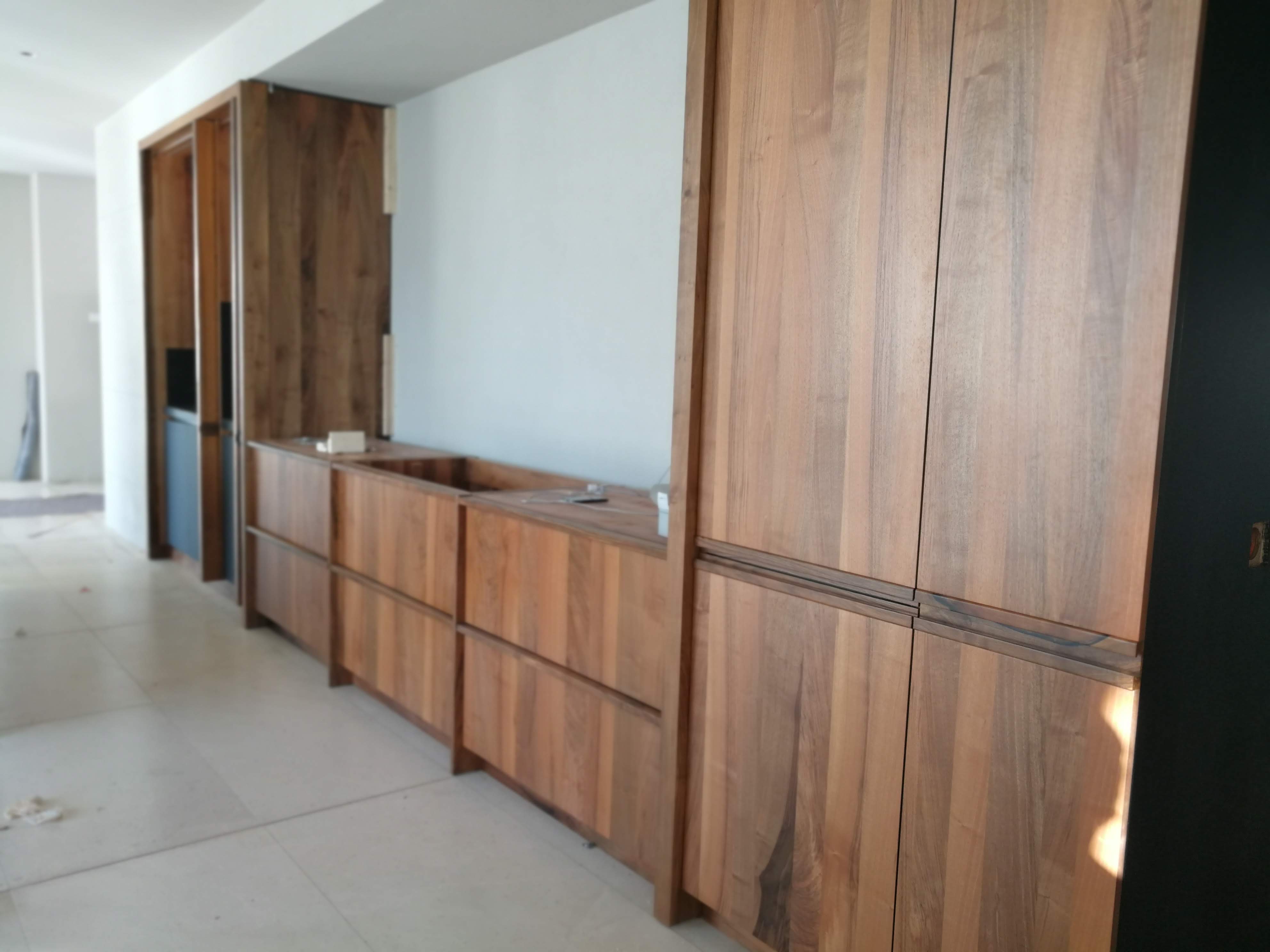 Corredor com frente de armarios e gavetoes em nogueira macica e portas de correr