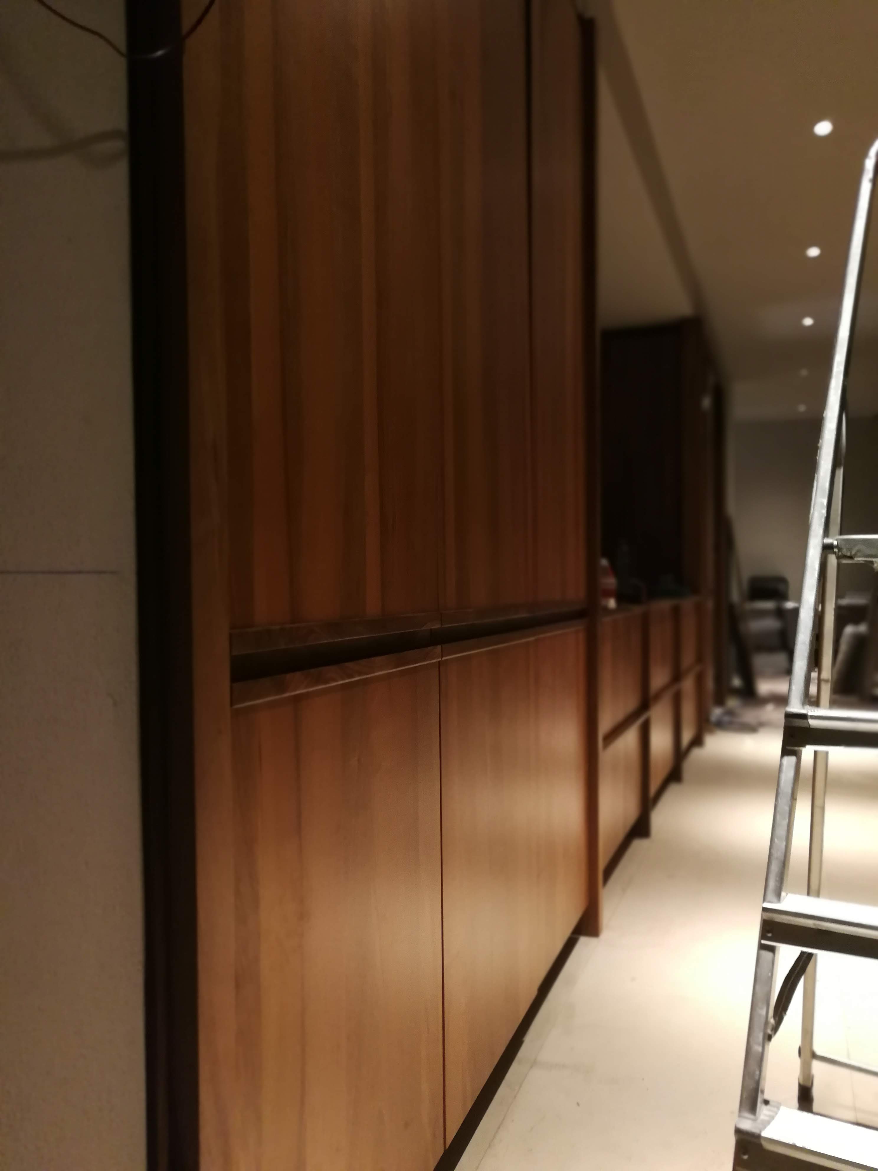 Corredor com armarios altos em nogueira escura em fase de montagem