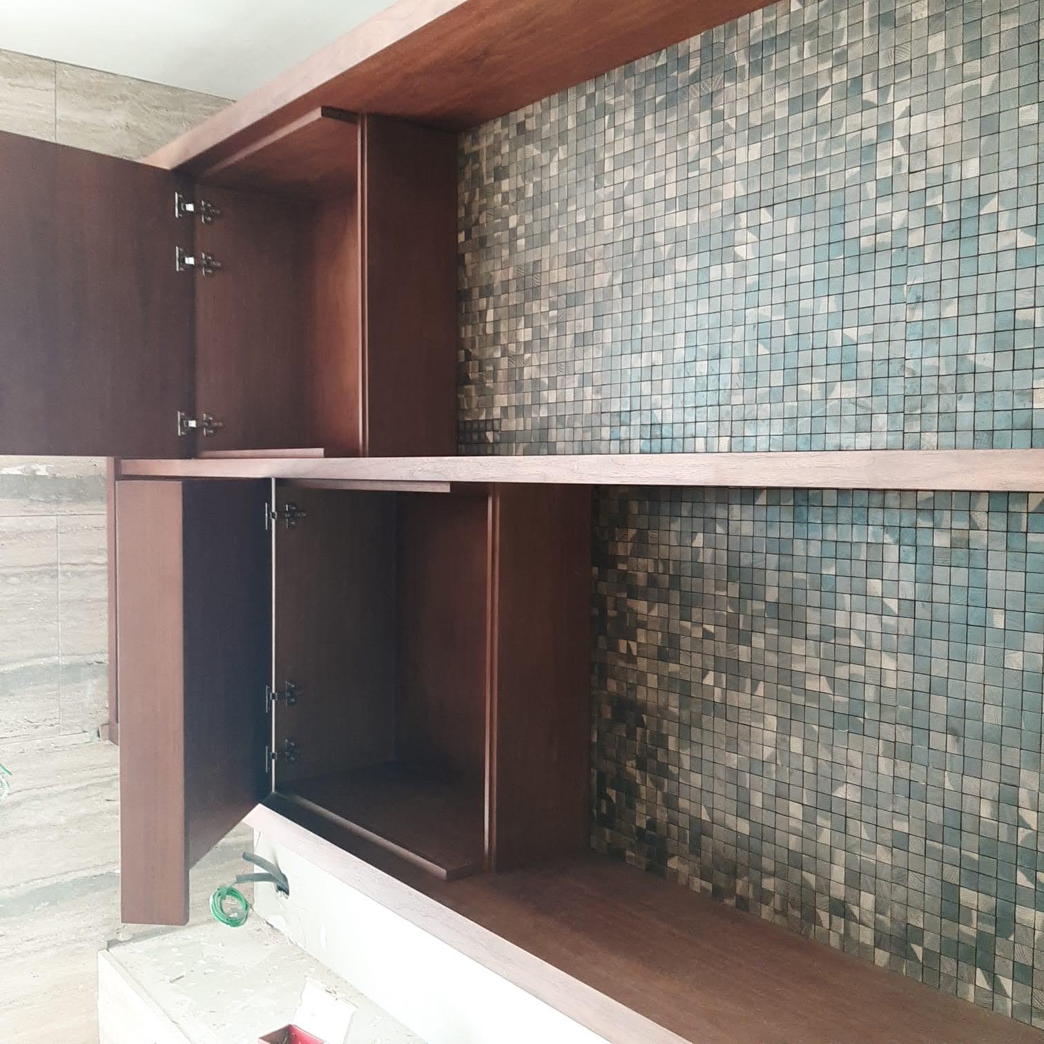 Movel em nogueira com nichos e parede em mosaico azul-esverdeado e dourado