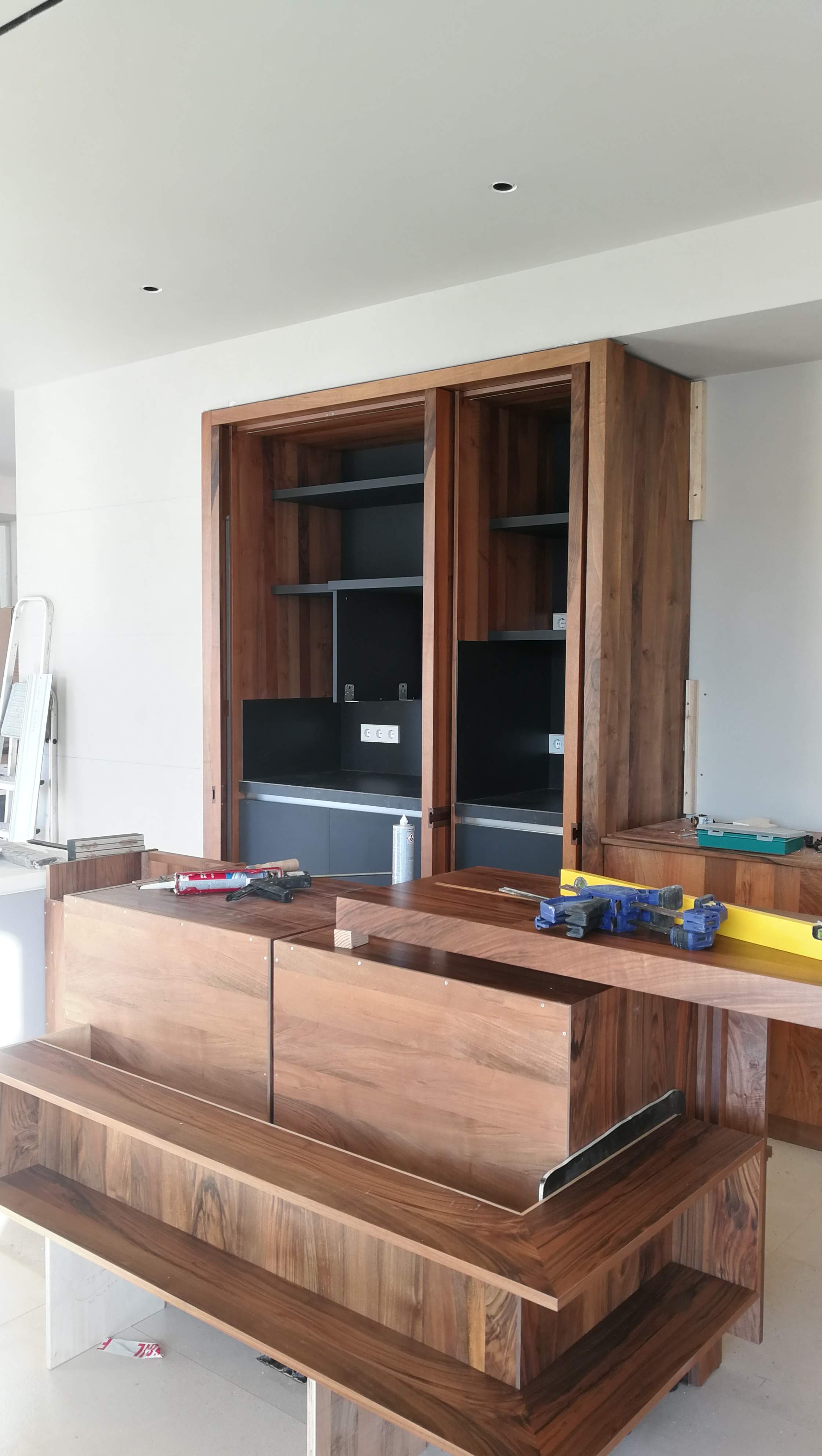 Movel de cozinha em nogueira com portas de correr abertas e prateleiras interiores