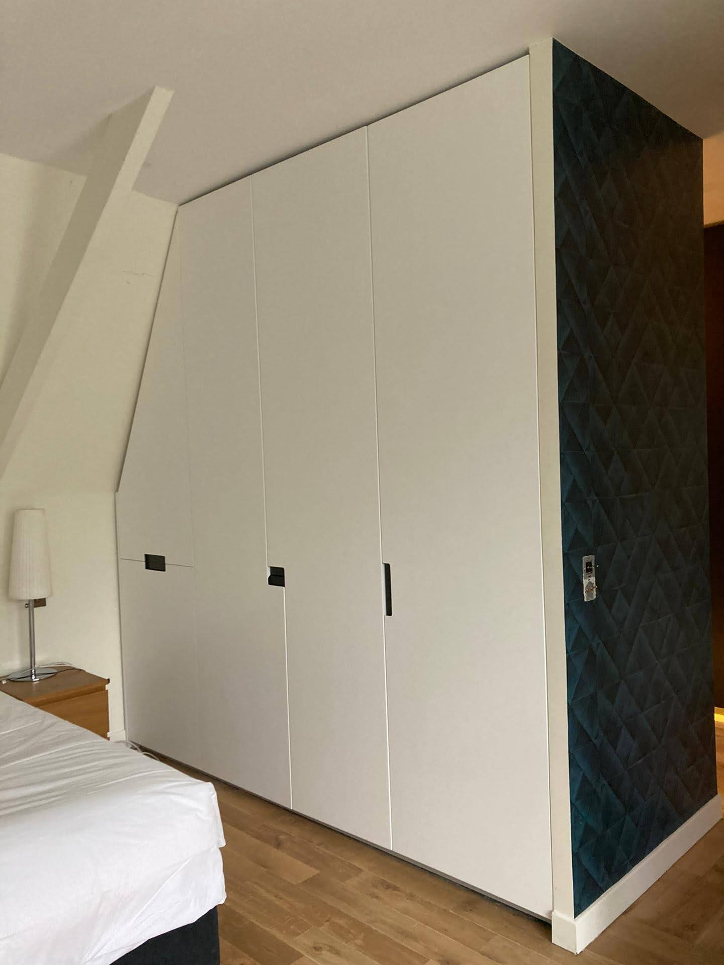 Quarto em sotao com armario embutido branco e papel de parede geometrico verde-azulado escuro